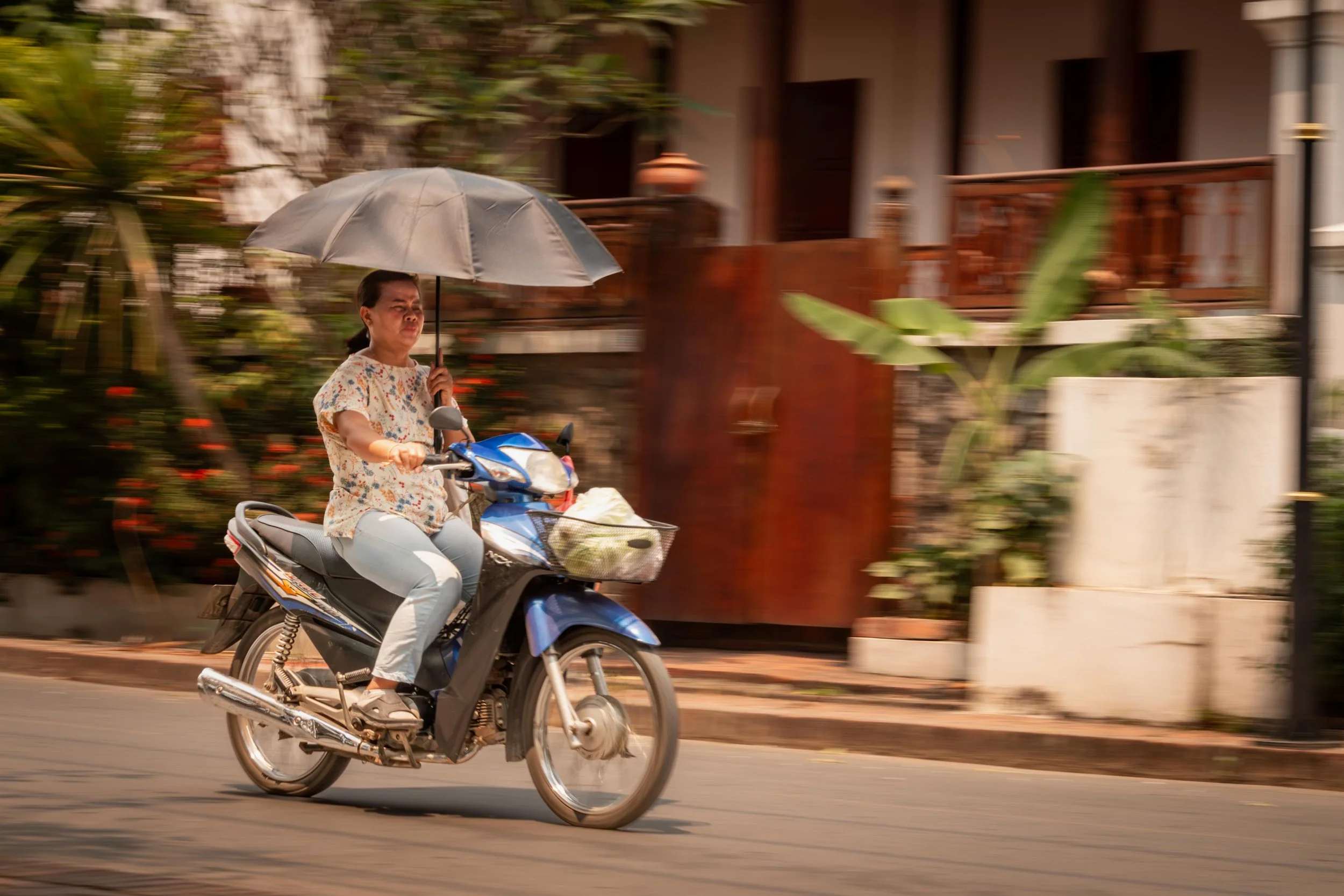 A Laotian lady carries her shade in the heat of Vientiane.