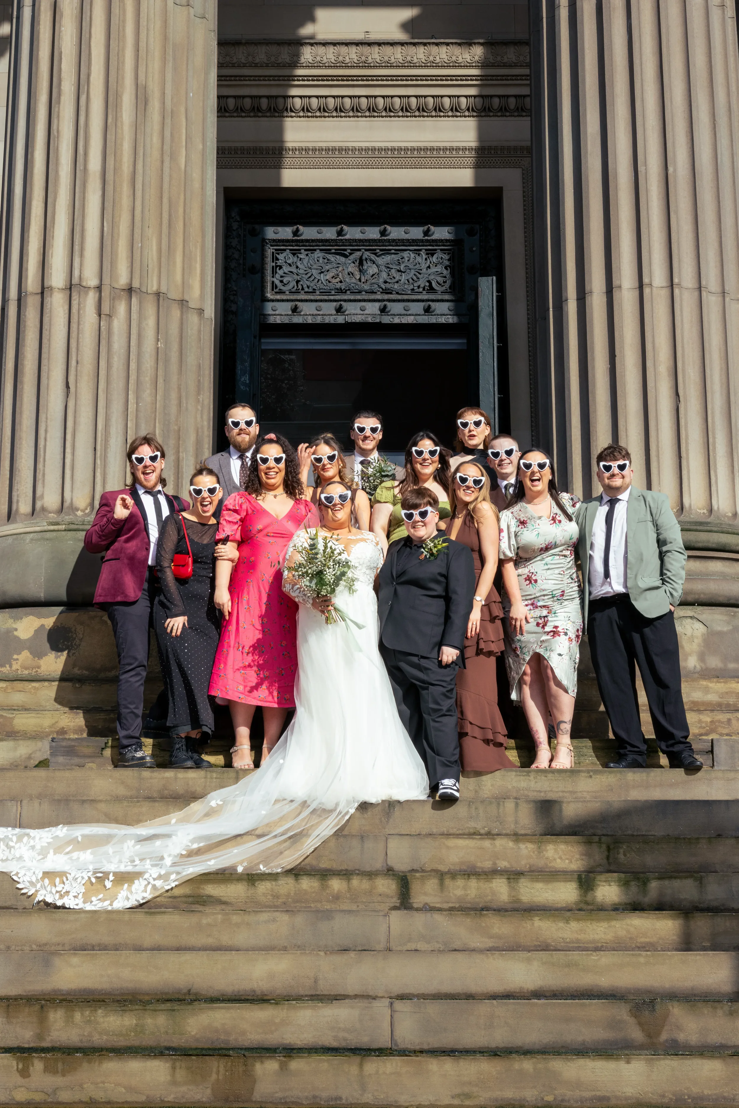 wedding party on steps of venue all in white sunglasses.webp