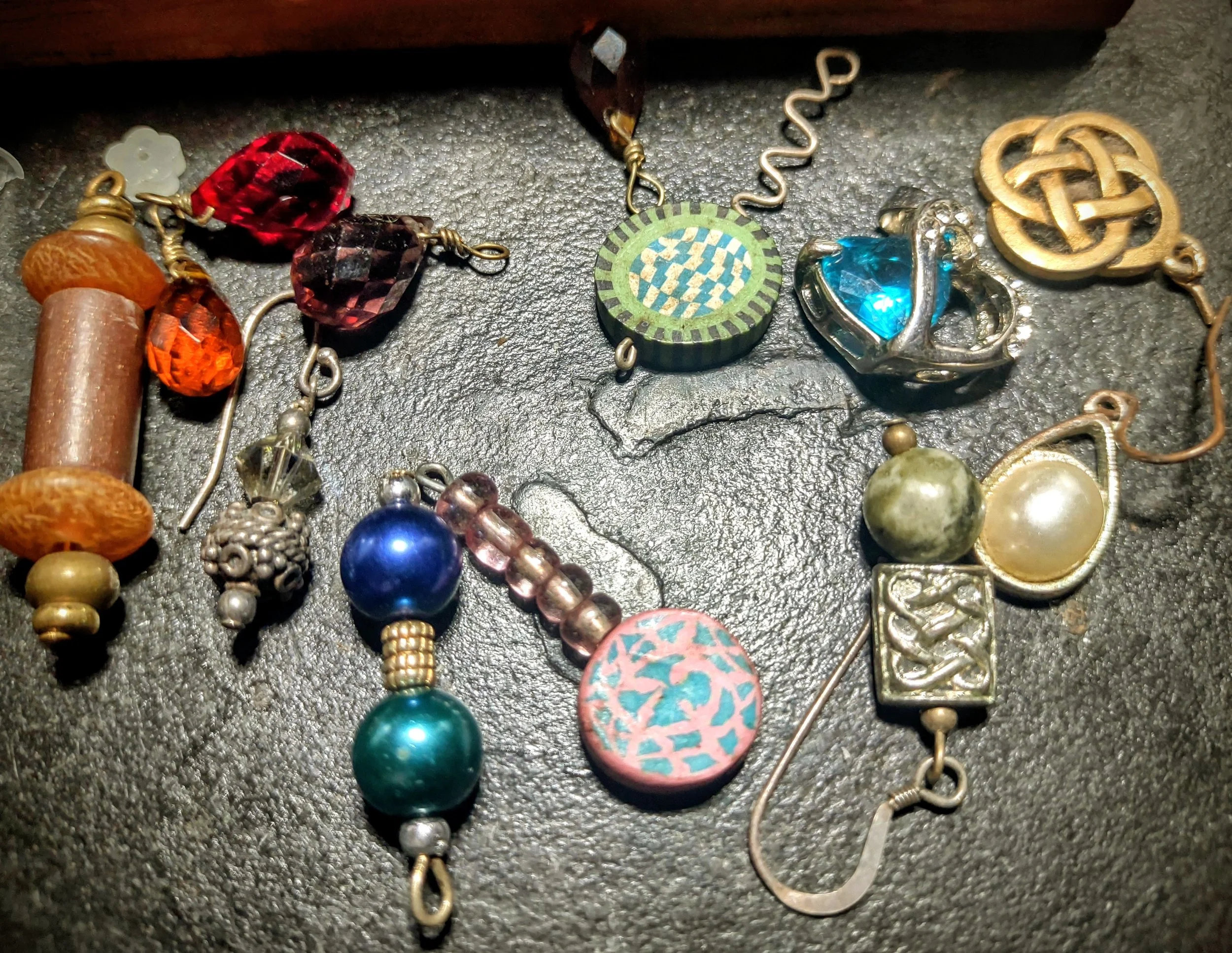 Single earrings and pendants being sorted for creative reuse