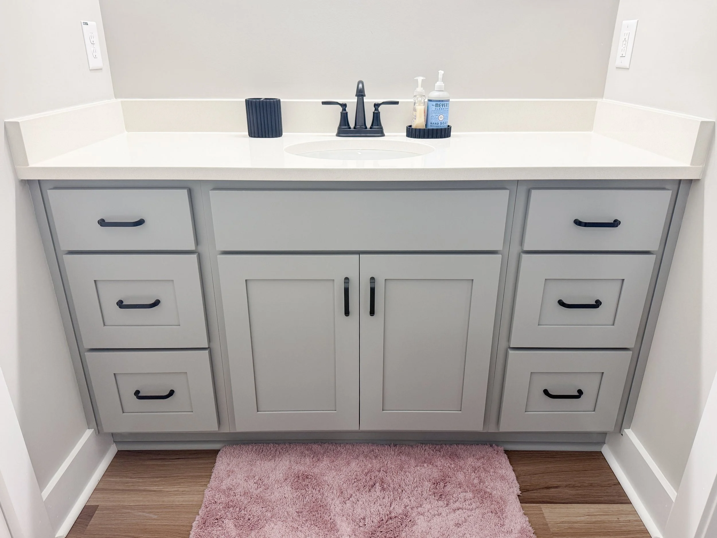 This custom vanity by MTW Cabinetry showcases Dawson doors combined with Slab drawer and 5-piece drawer fronts, finished in a versatile gray.
