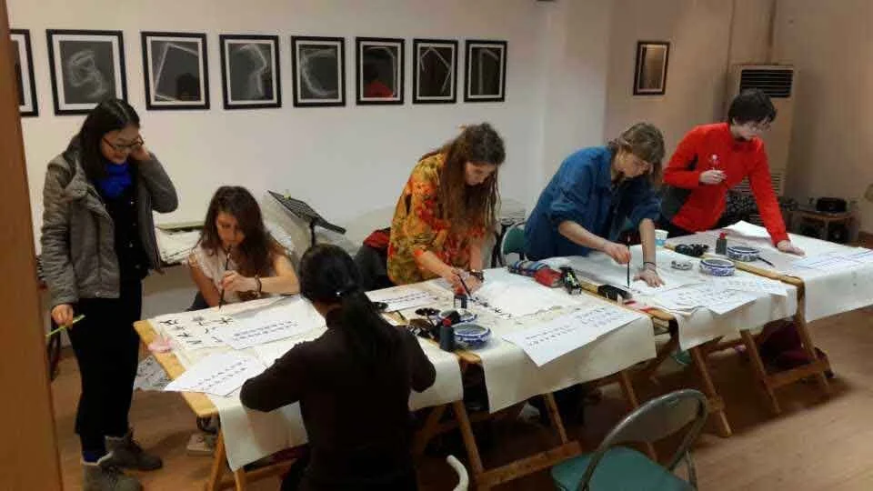 Artist Zhang Yuxue (张玉雪), a former student of Le Xi (奚乐), leading a Chinese ink painting workshop for Putney School students, demonstrating the artistic lineage and cultural exchange.