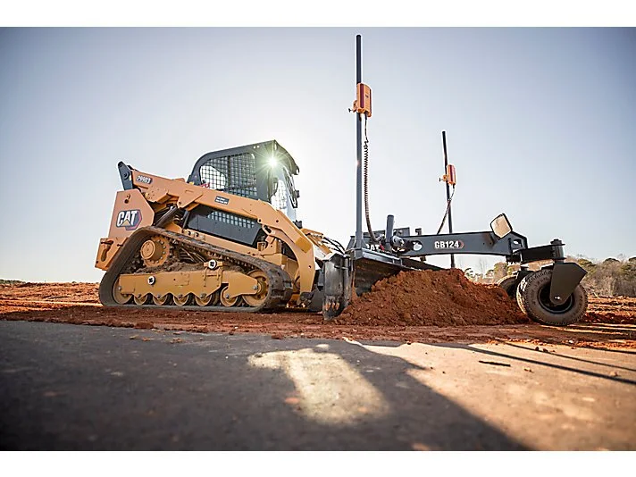 A bulldozer grading a dirt road at a construction site.