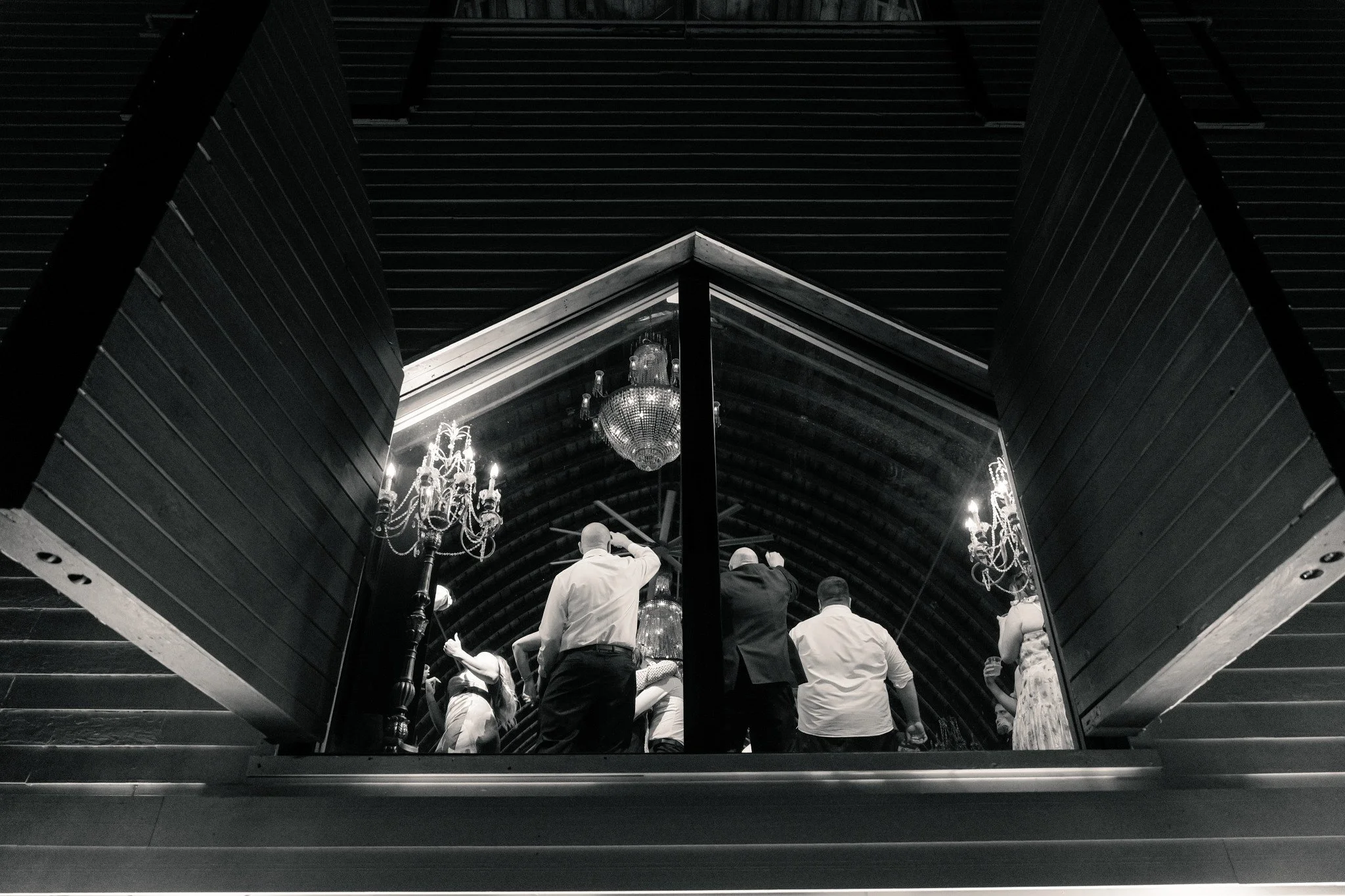 A wedding reception, at Green Acres Events, continues late into the evening.  This is a unique view of it from outside, looking in through the big hayloft window. 