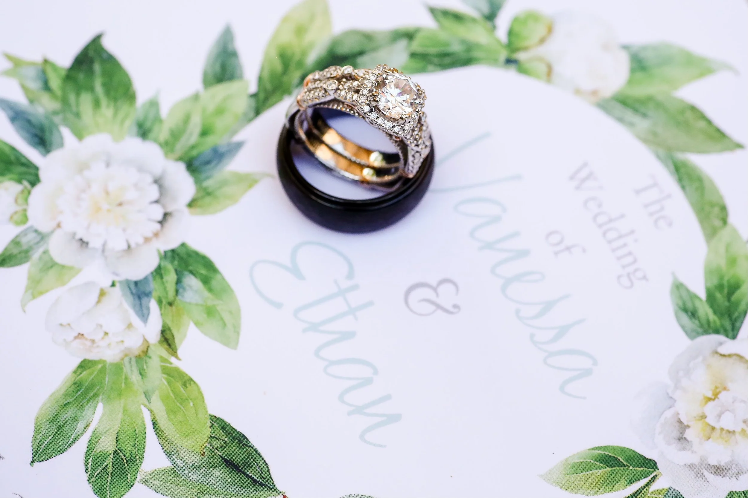 Minnesota wedding and portrait photographer, Leah Welch, takes a picture of a beautiful wedding band set on top of a wedding program.