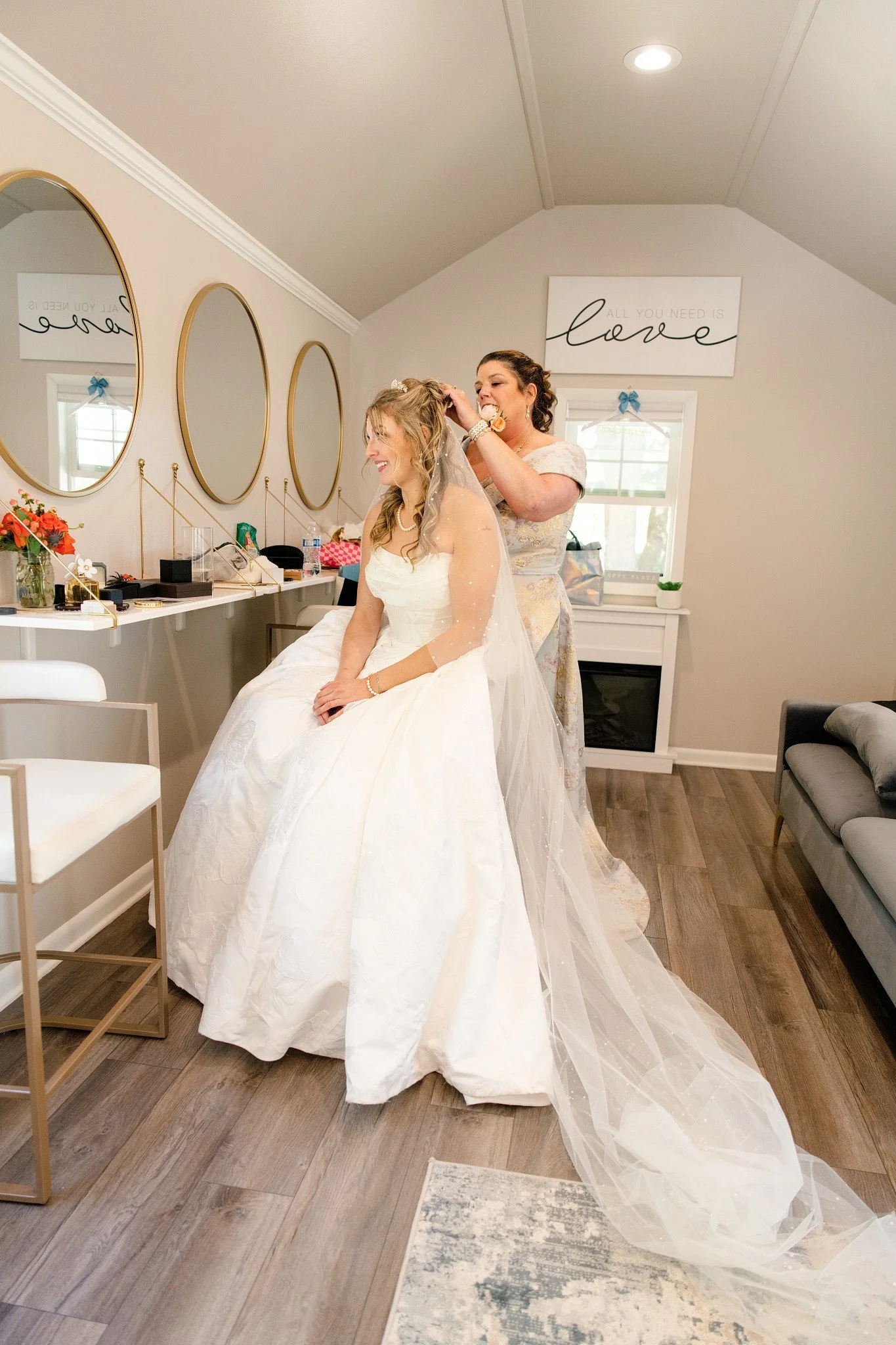 The mother of the bride helping put the veil on her daughter.