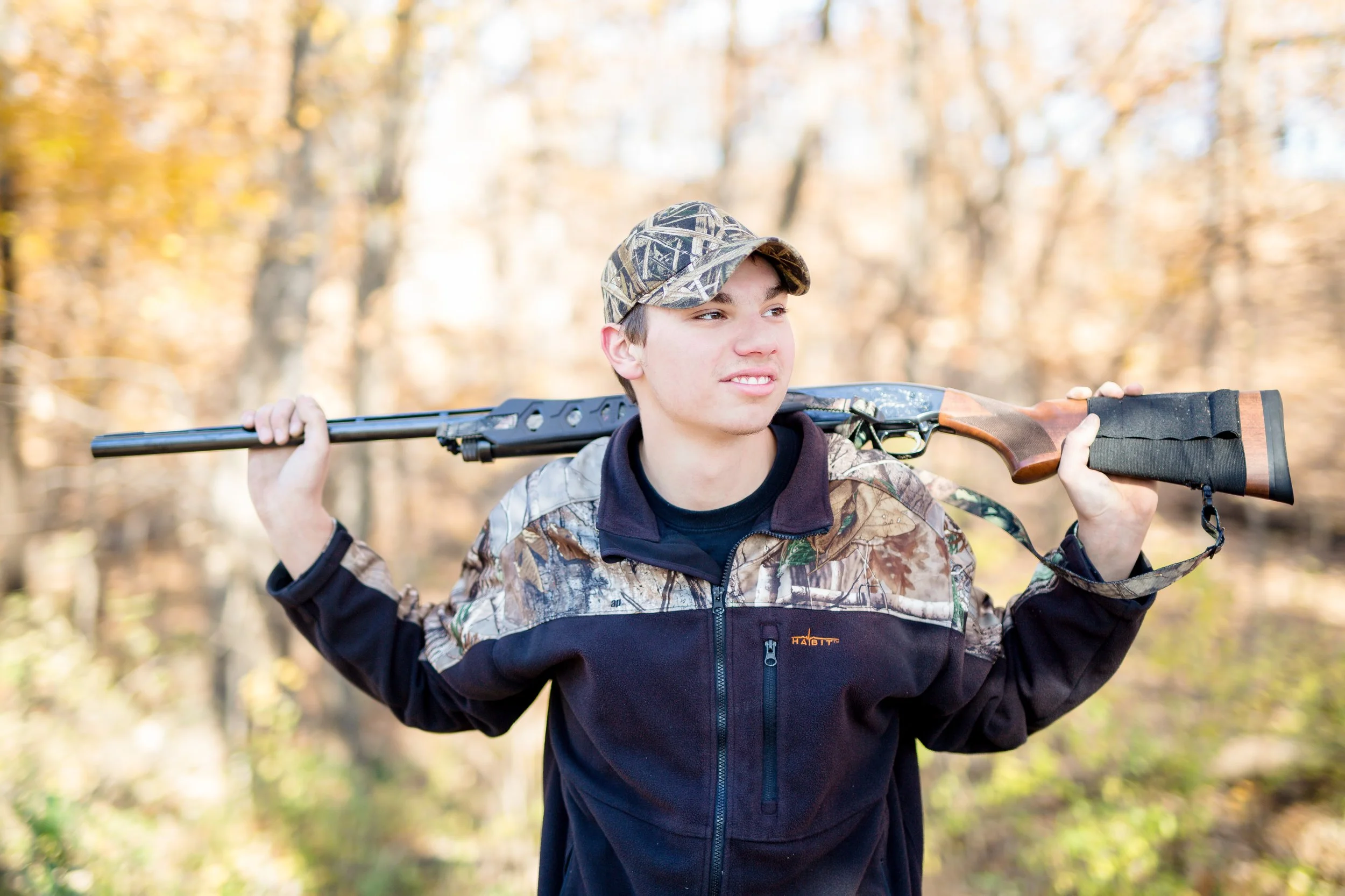 Senior photo of a young man and his hunting rifle, taken by LKW Photography in Minnesota.