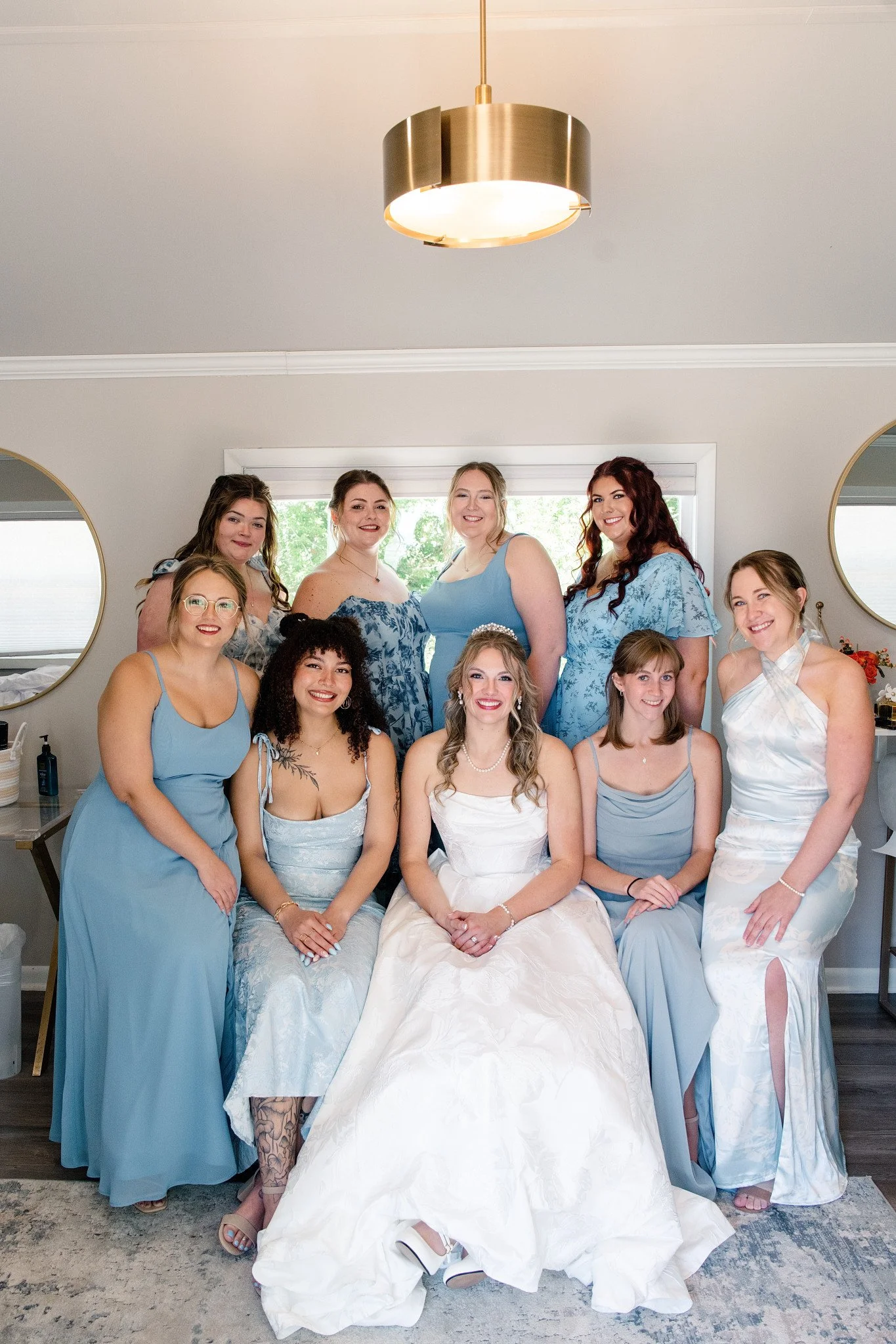 Bride and bridesmaids posing for a photo in shades of blue, at Green Acres Events, inside their bridal cottage.