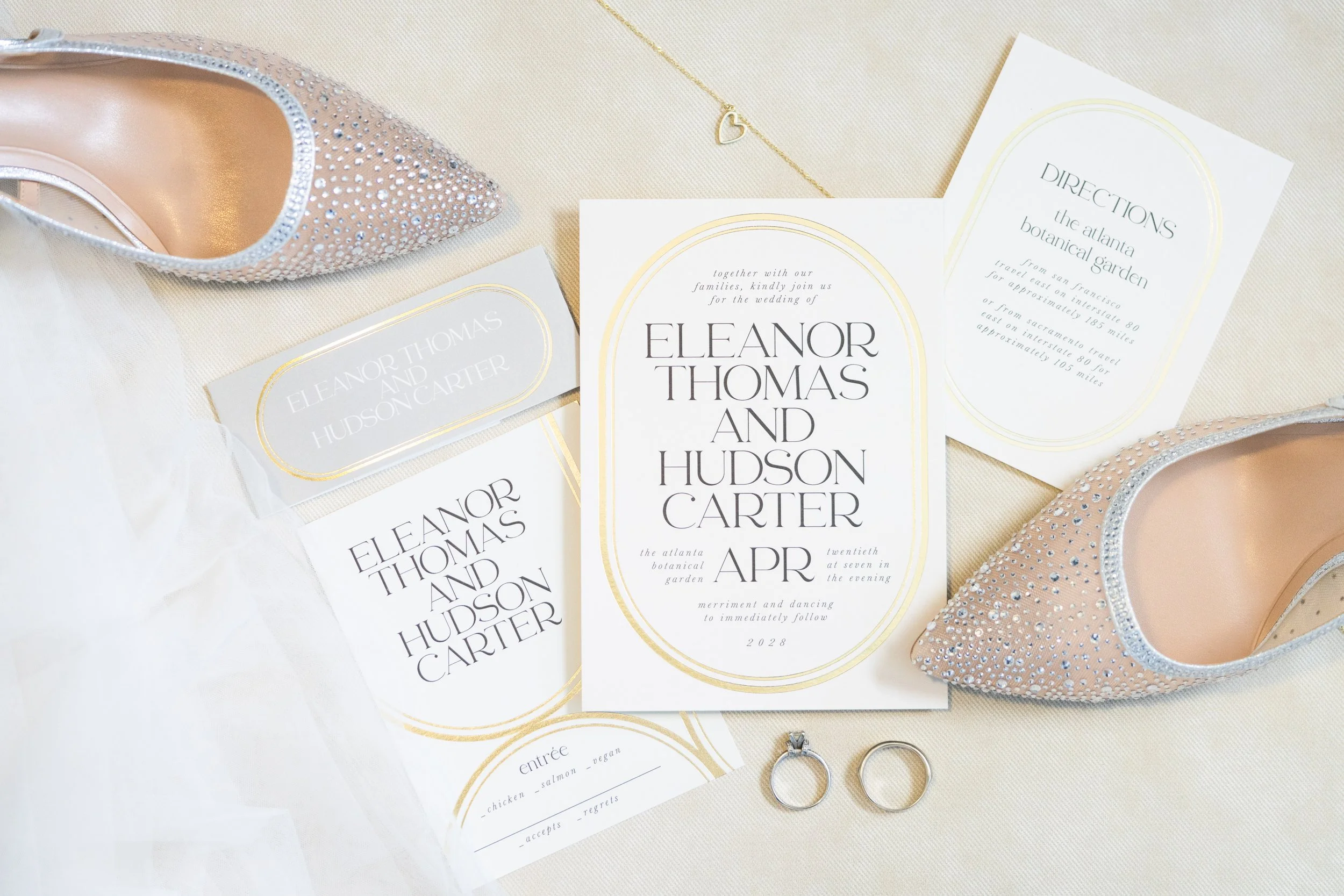 Flat Lay photo of wedding invitations, rings, shoes, and veil, taken by Minnesota wedding photographer, LKW Photography