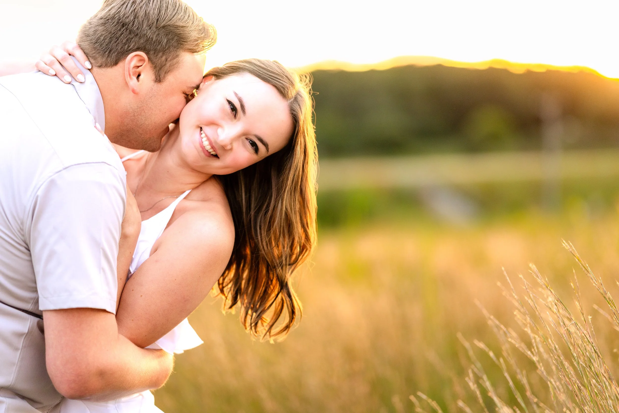 Engaged couple outdoors during sunset, in a grassy field, taken by MN photographer LKW Photography.