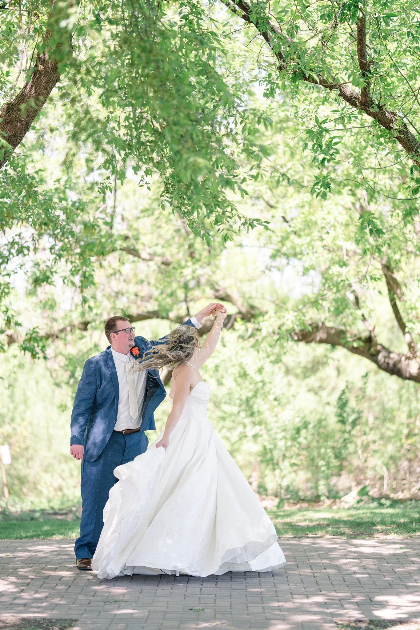 Groom twirling his bride during a first look to get a good look at her in her wedding dress.