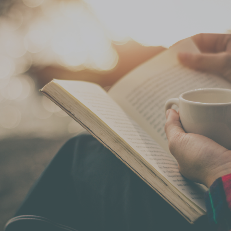 Book Tours with Hawthorn & Aster : Hands holding open a book, with one hand cradling a mug