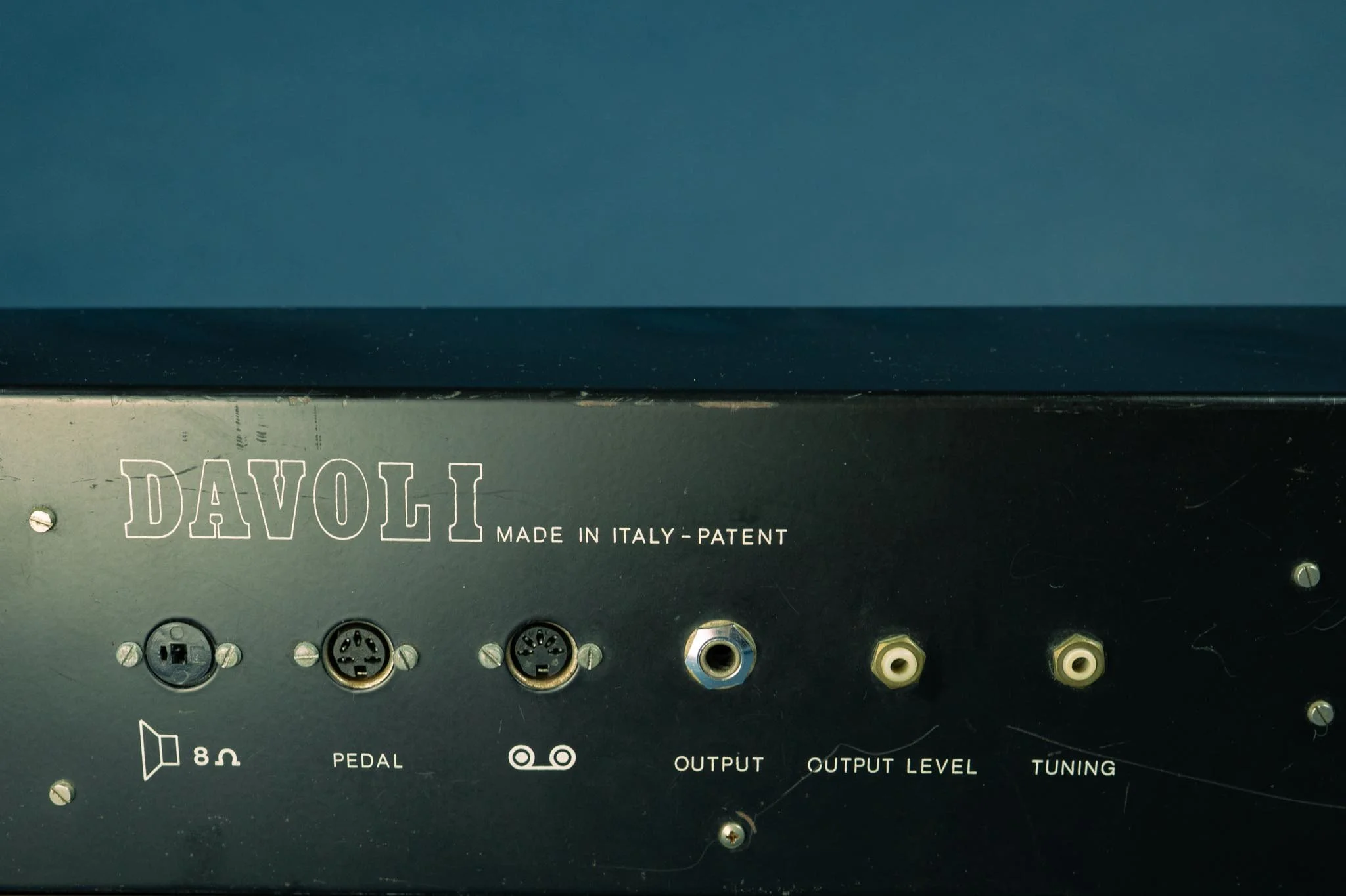 A quick glance in the back and you understand we're at the dawn of the synthesizer age. 2 pin din Hi-Fi speaker connector, tuning and output regulation is a tiny hidden potentiometer that requires a screwdriver, and the 5 pin connector with the curls