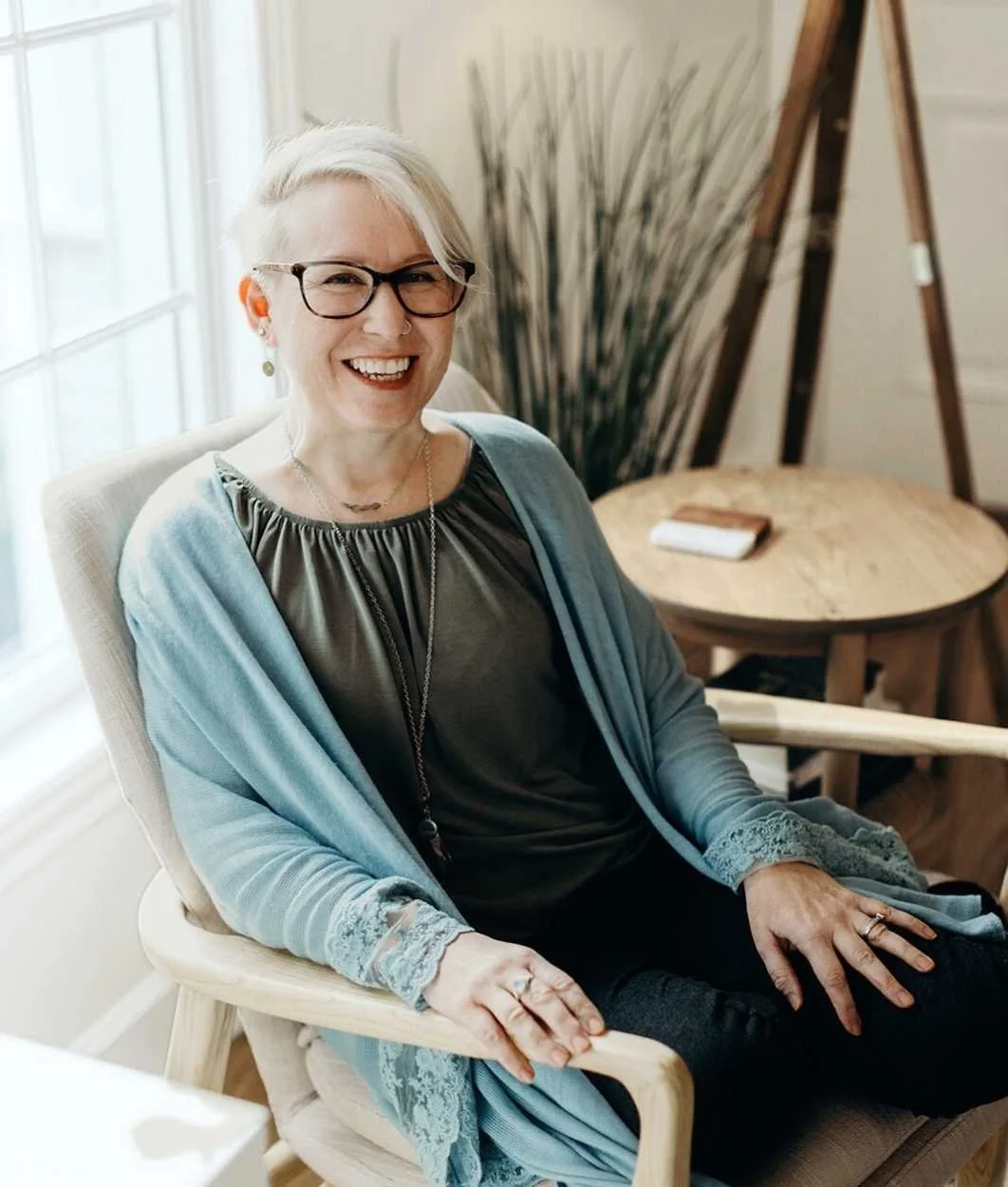 Reset therapist Rachel White wears a blue cardigan and sits in a chair