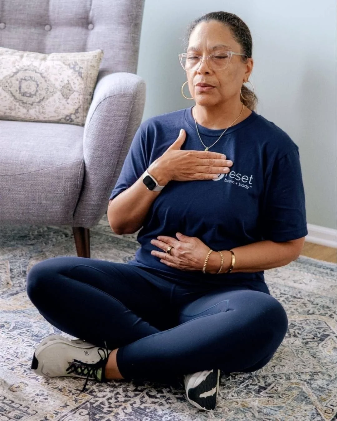 Reset Therapist Kim Evans, LLMSW breathes deeply in a seated position