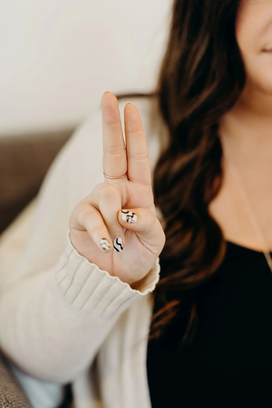 A Reset therapist demonstrates how EMDR thera is offered, holding up two fingers with one hand, and holding a Neurotek device in the other. 