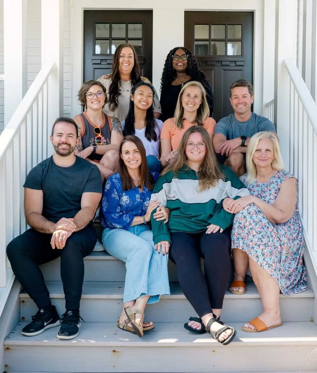The Reset Farmington team sits on the steps leading to their office