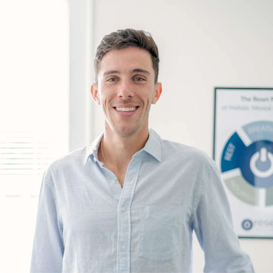 A male therapists stands, smiling.