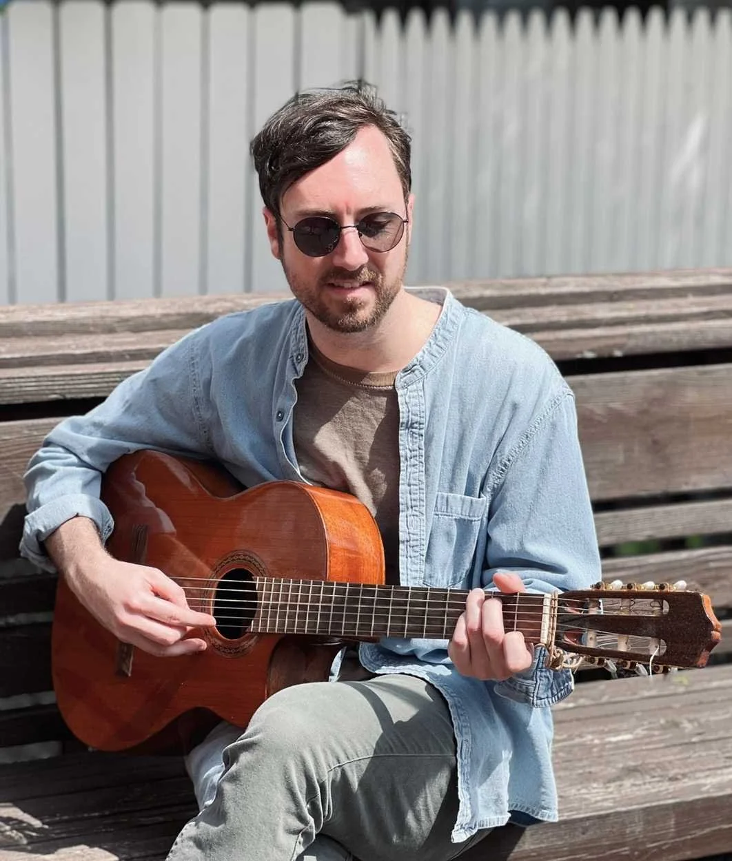 Reset therapist Jim Byrne sits outdoors and plays the guitar