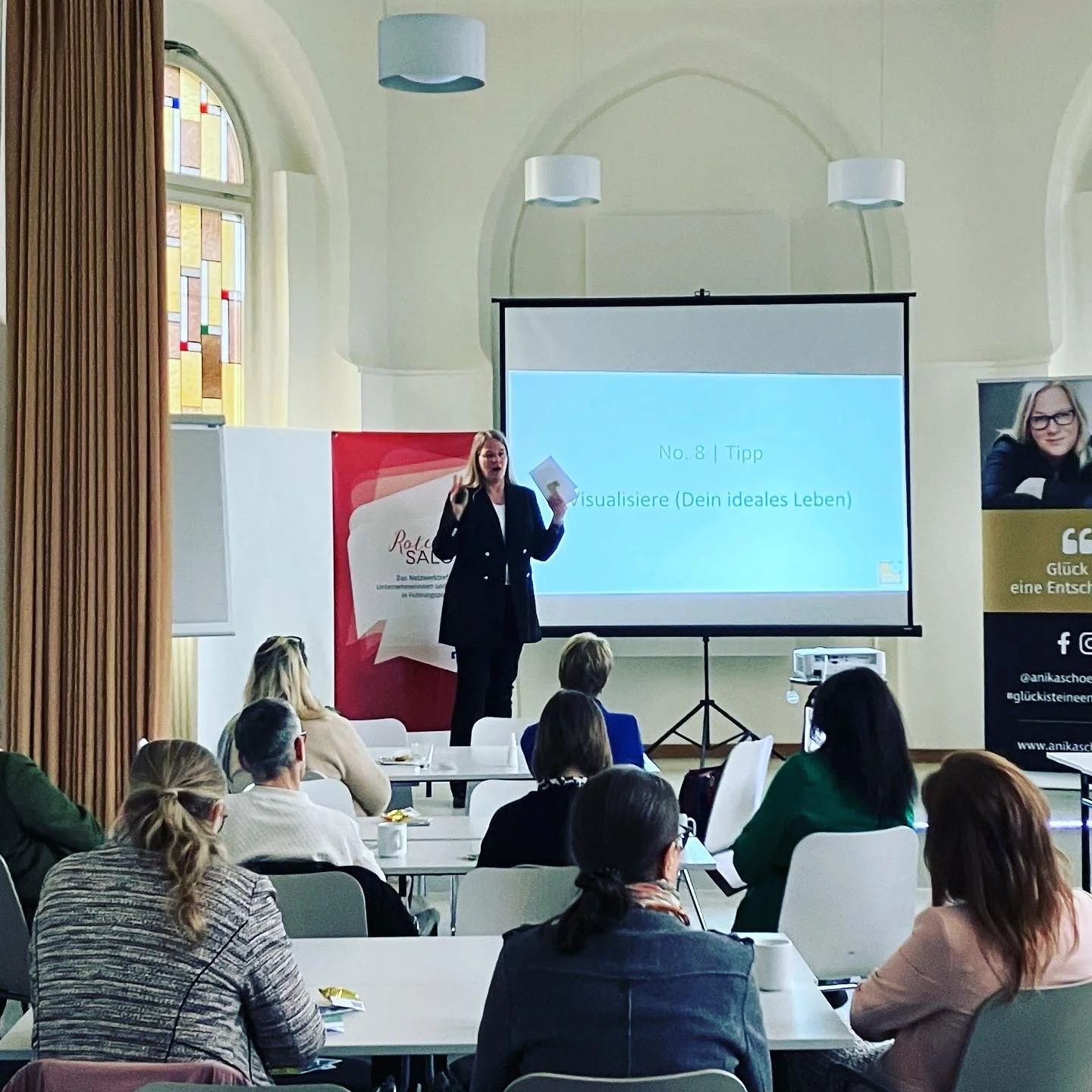 Speakerin und Glückstherapeutin Anika Schön im Vortrag bei der IHK Lüneburg-Wolfsburg vor Publikum.