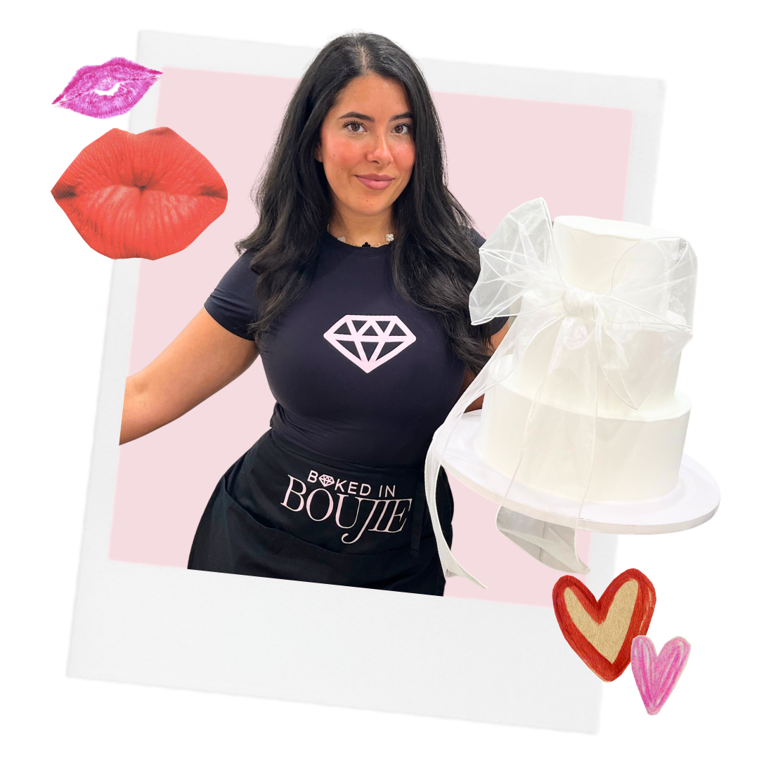 A woman with long dark hair wearing a black T-shirt with a diamond logo and the text "Baked in Boujie" stands next to a white, two-tiered cake with a sheer white ribbon bow on top. Pink lips, a pink lip print, and red and pink hearts are around the photo template with a pastel pink background.