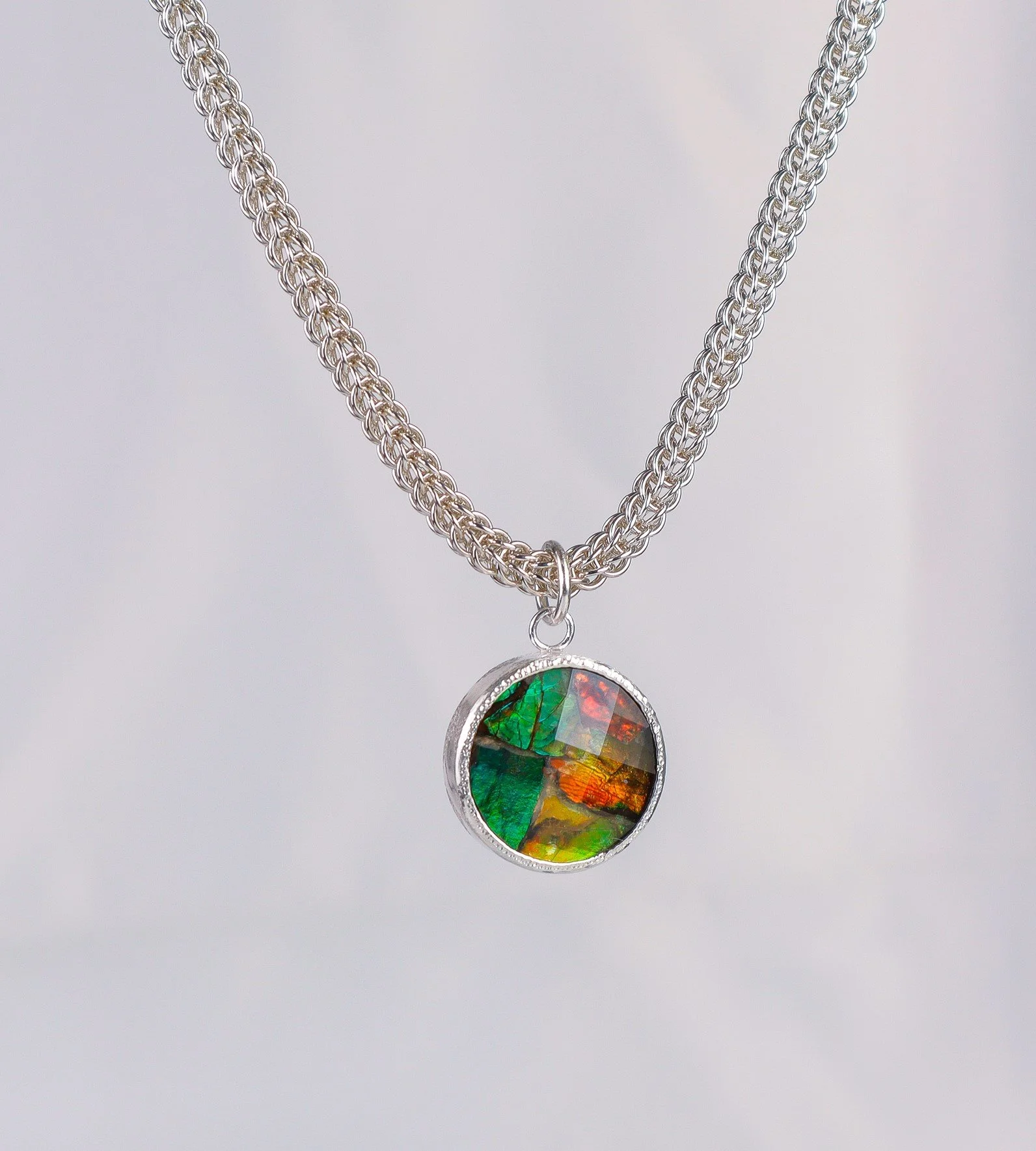 Faceted ammolite in silver pendant with handwoven chain