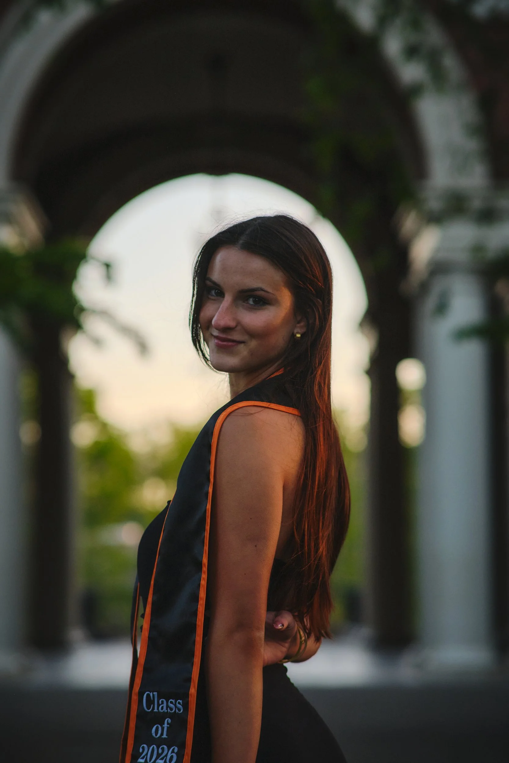 OSU graduate portrait at golden hour under a campus archway in Corvallis, Oregon