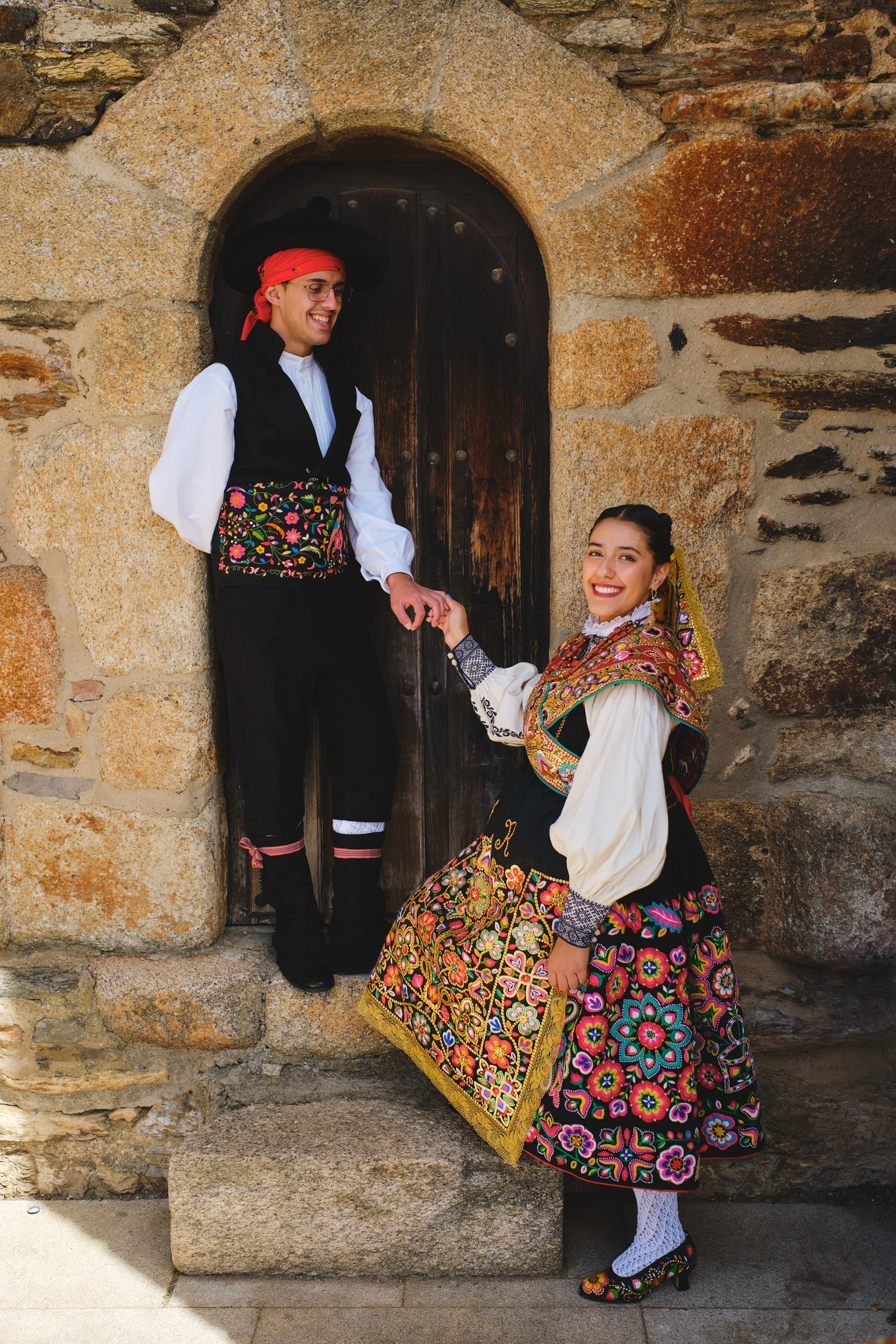 Couple in traditional dress in a stone doorway during Los Quintos in Spain