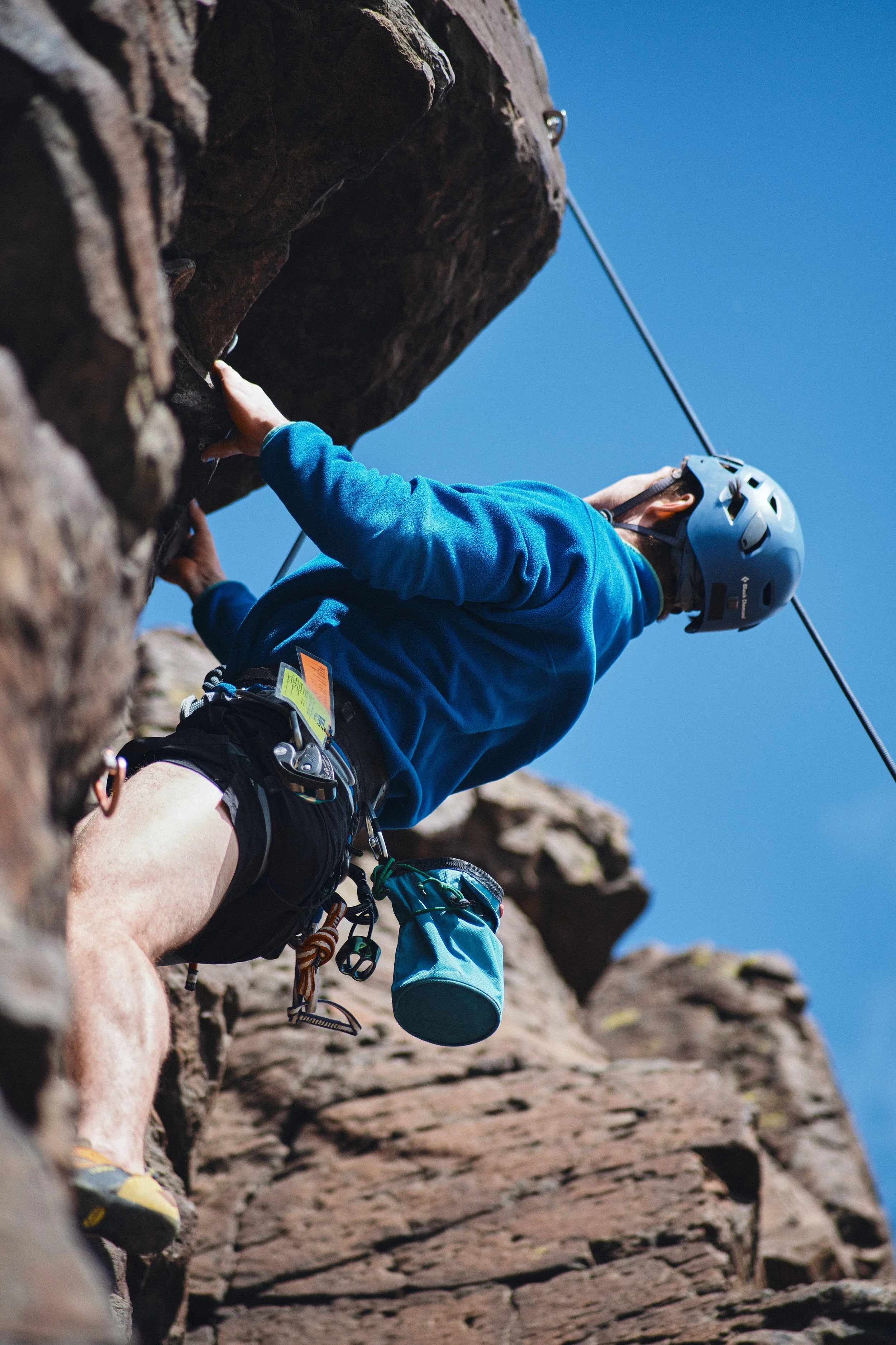 Rock climber on a cliff against a blue sky