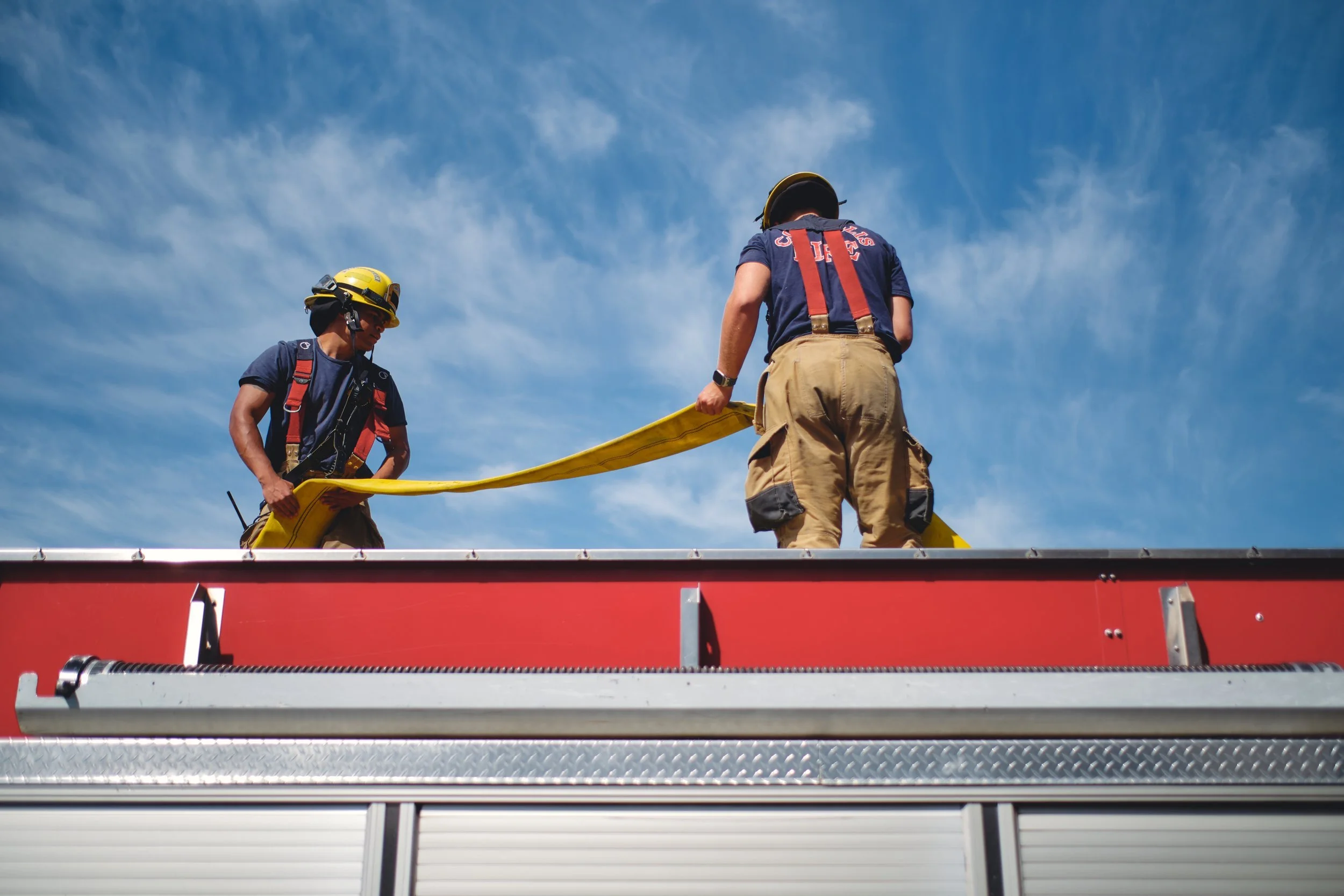 Corvallis firefighters working on top of a fire engine
