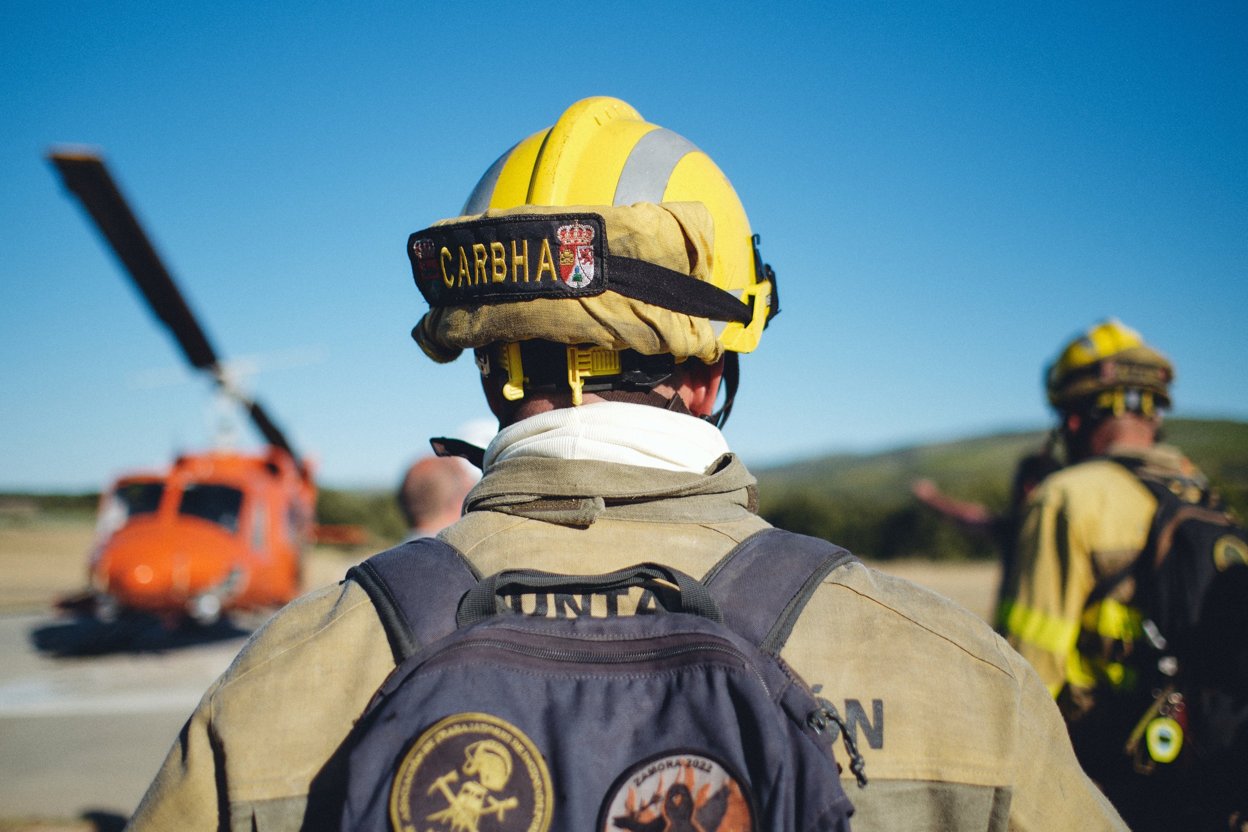 Forest firefighter in a helmet with a helicopter in Spain