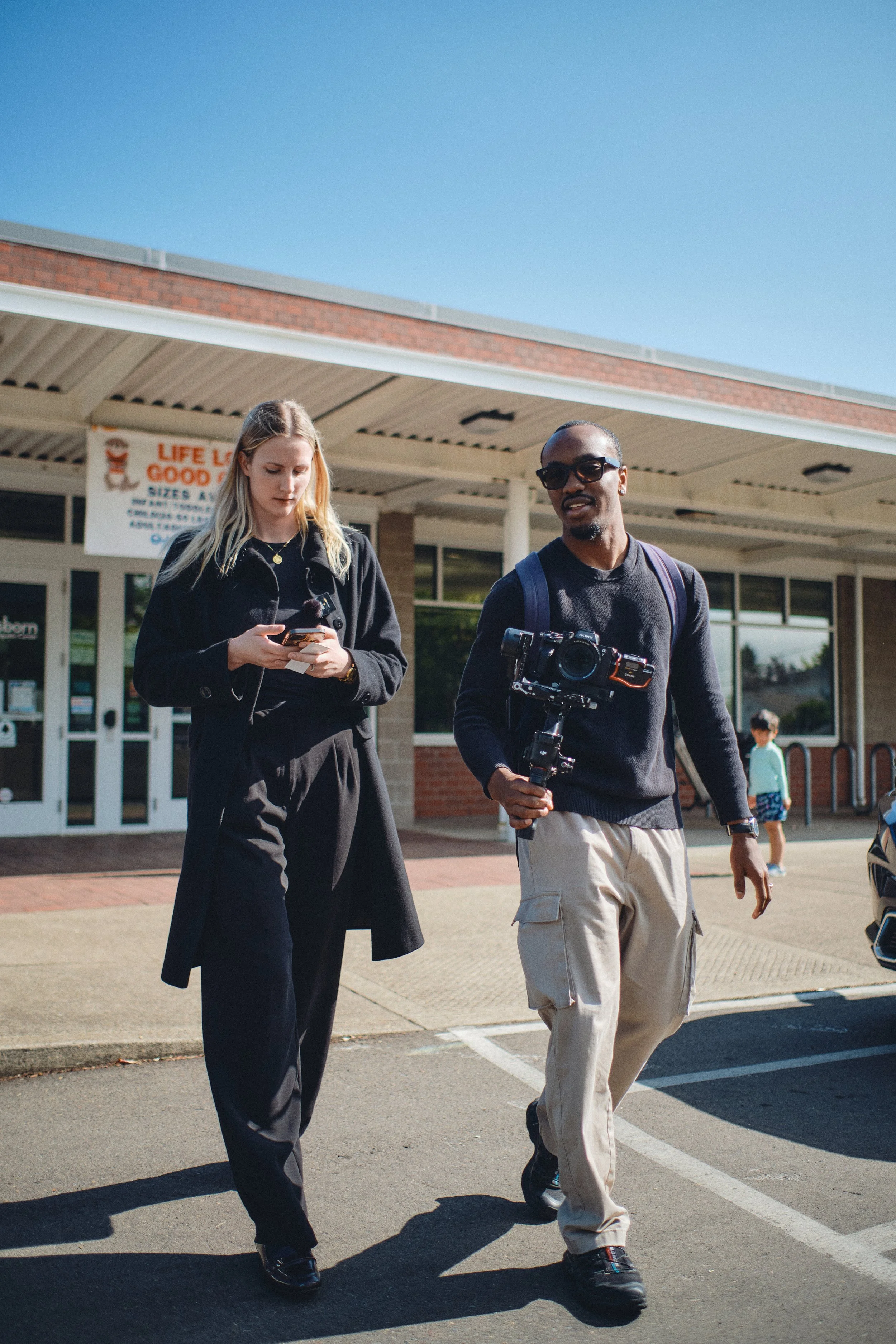 Two people walking out of an aquatic center during a brand shoot