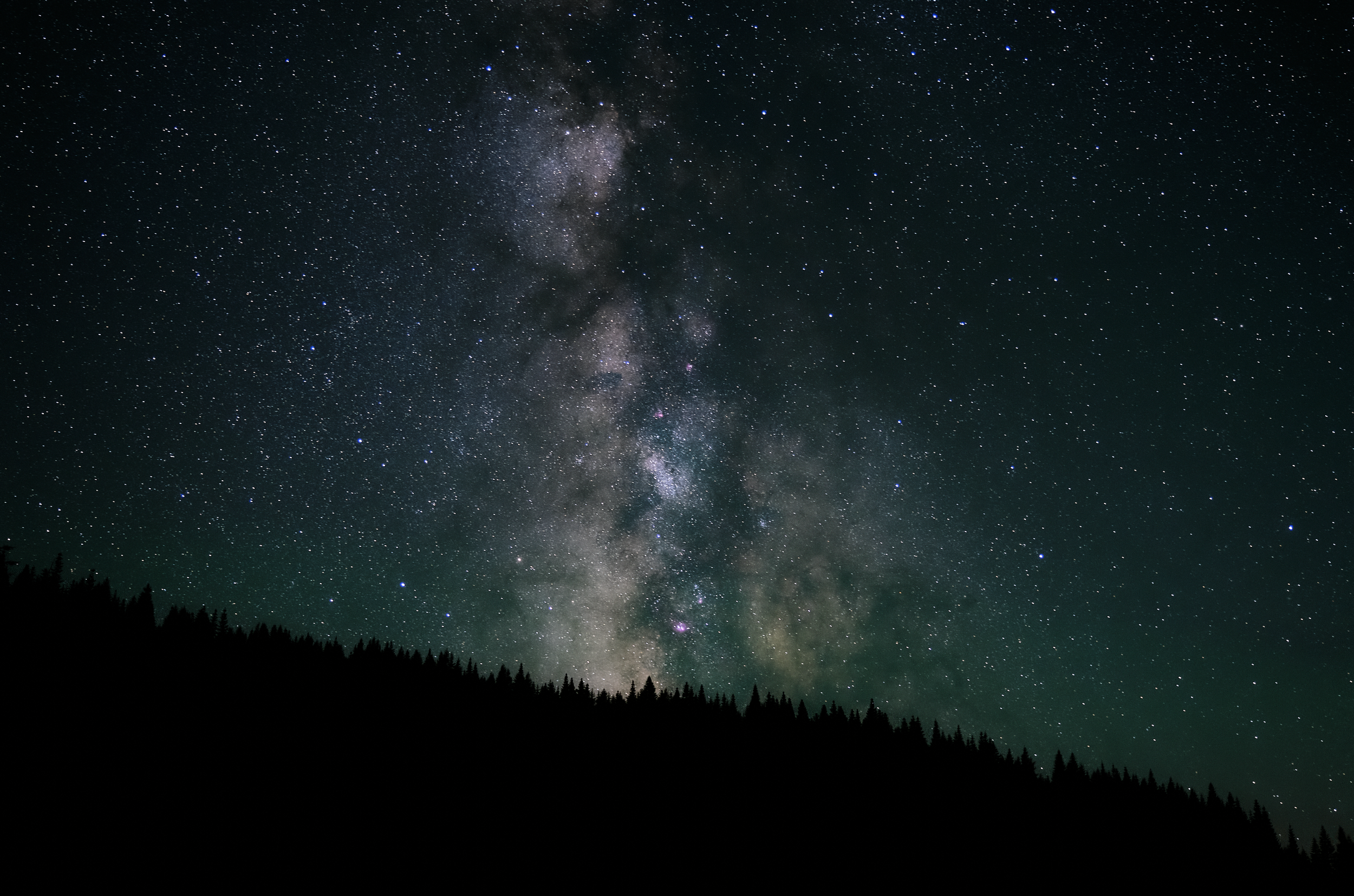 Milky Way over a forested ridgeline at night