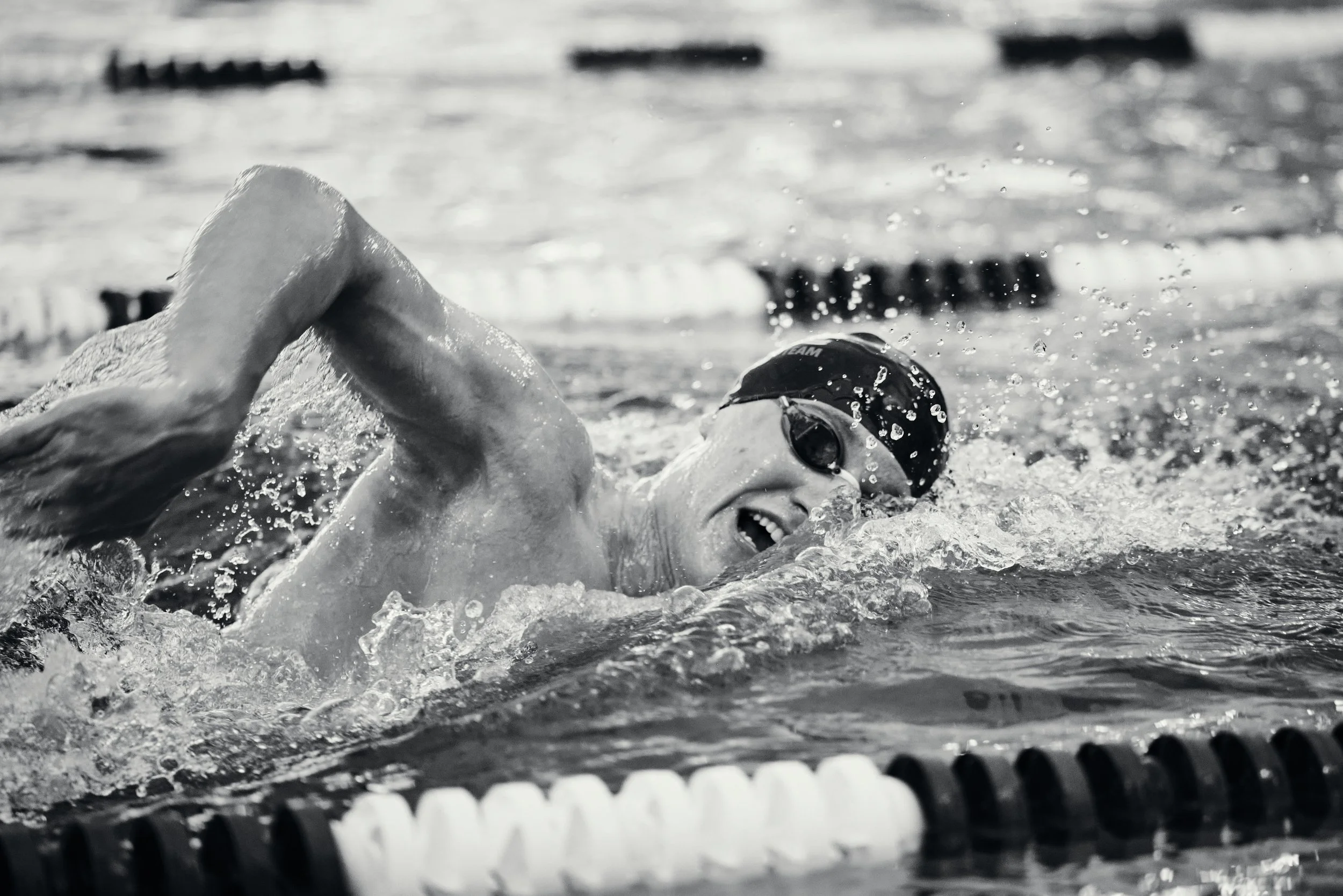 Black and white photo of a freestyle swimmer in a pool lane
