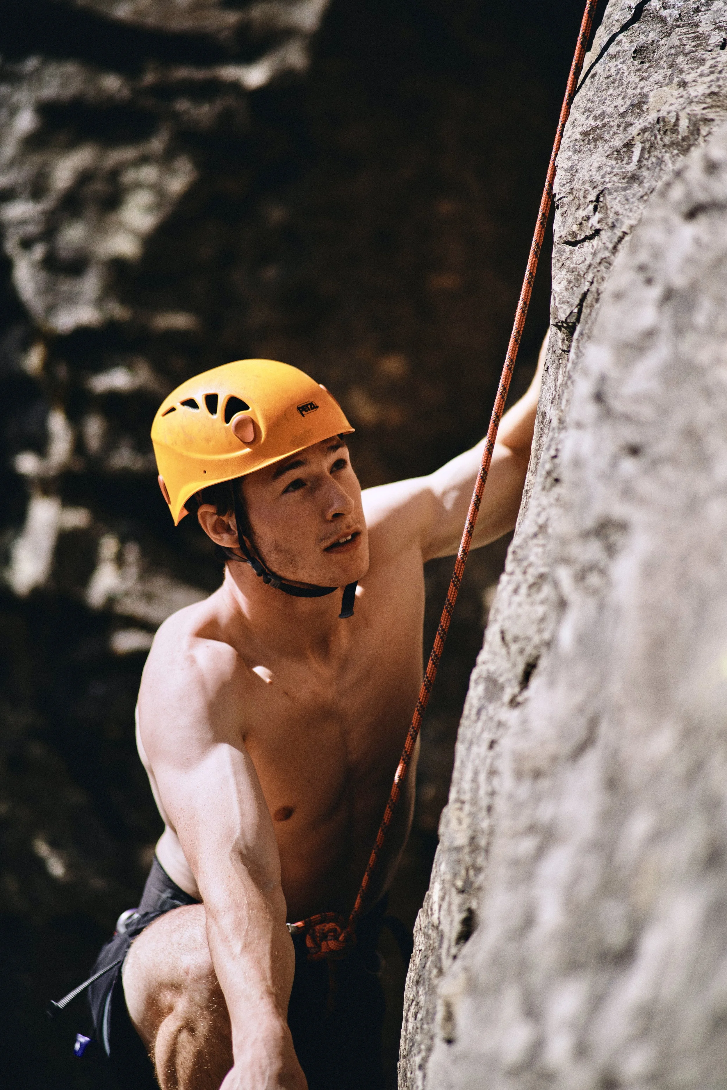 Rock climber in a yellow helmet on a rock wall