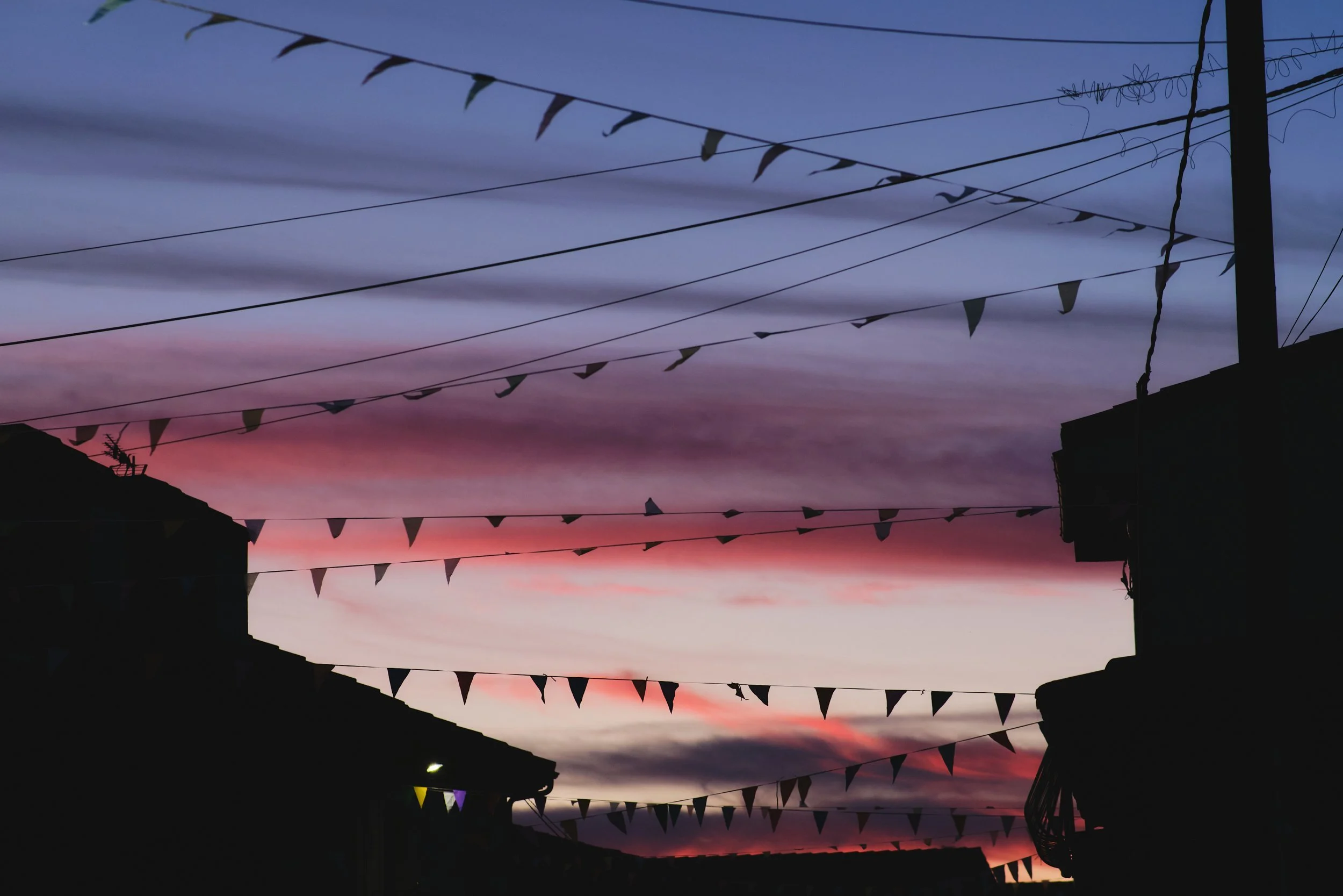 Sunset over fiesta flags in a Spanish village