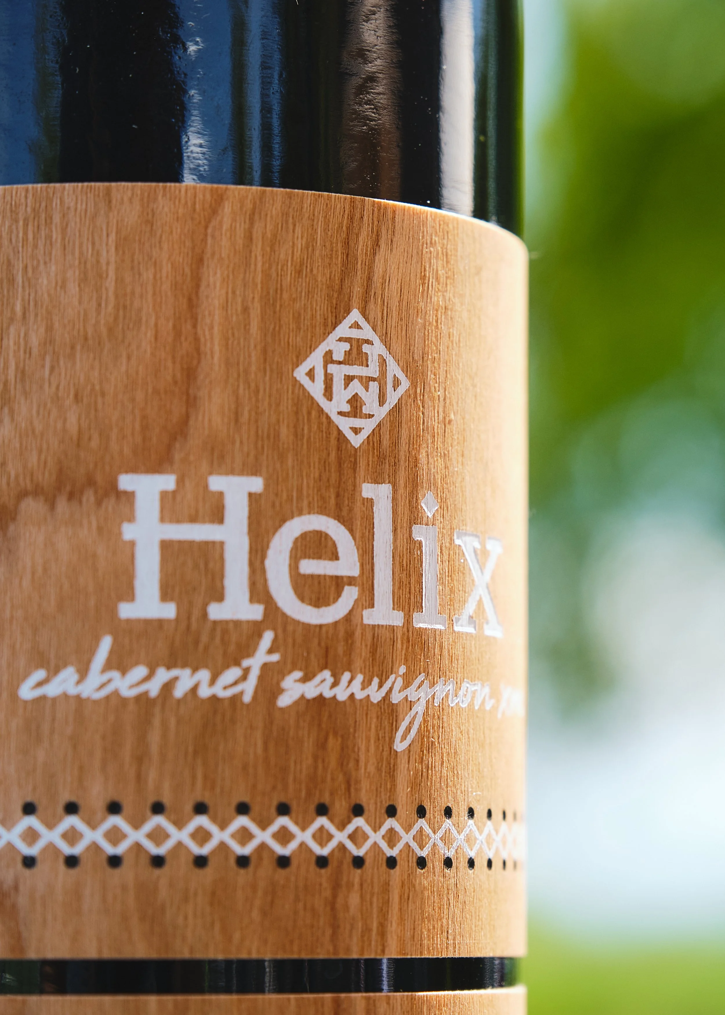 Close-up of a Cabernet Sauvignon label on a wood-textured bottle