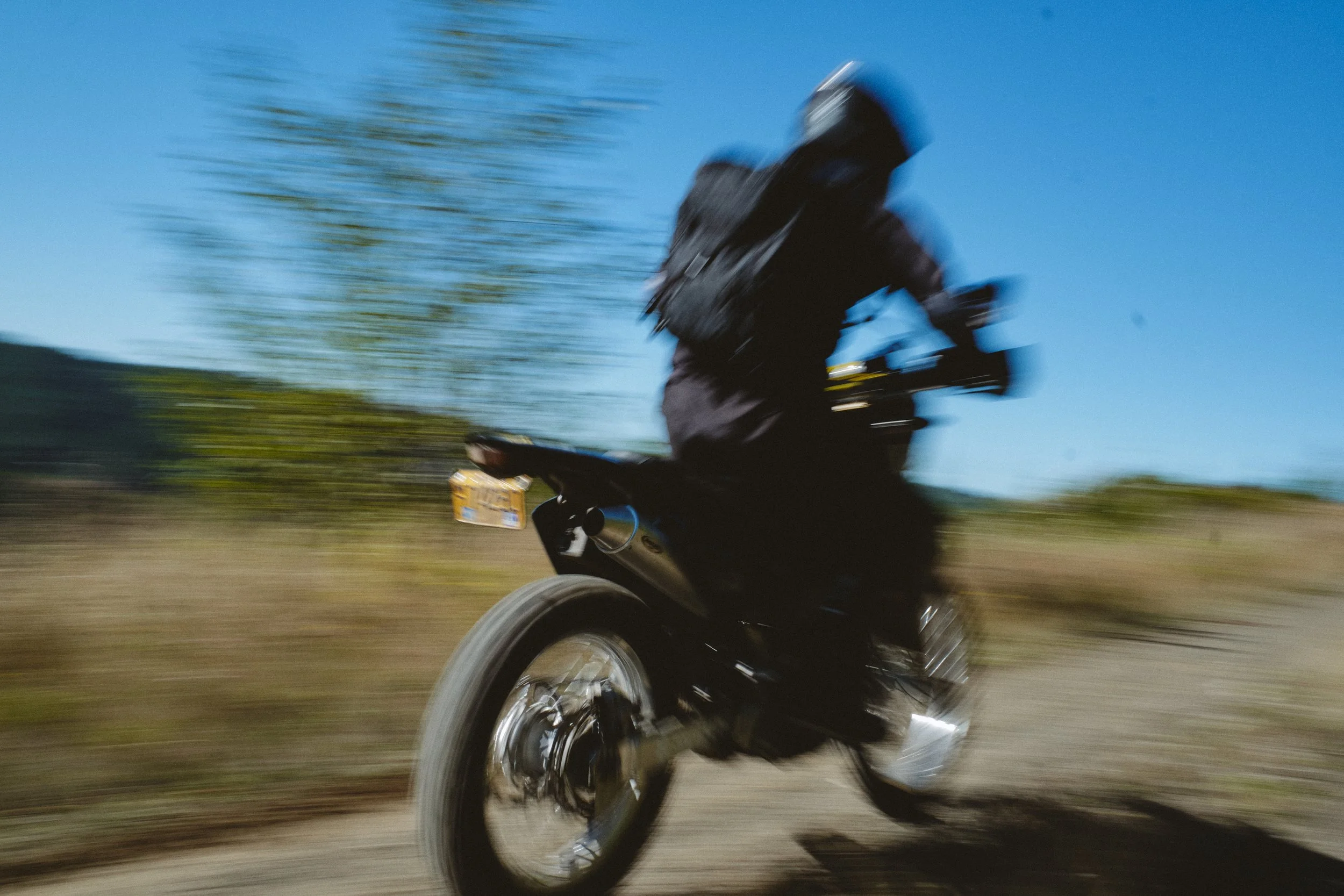Dirt bike rider speeding down a forest road