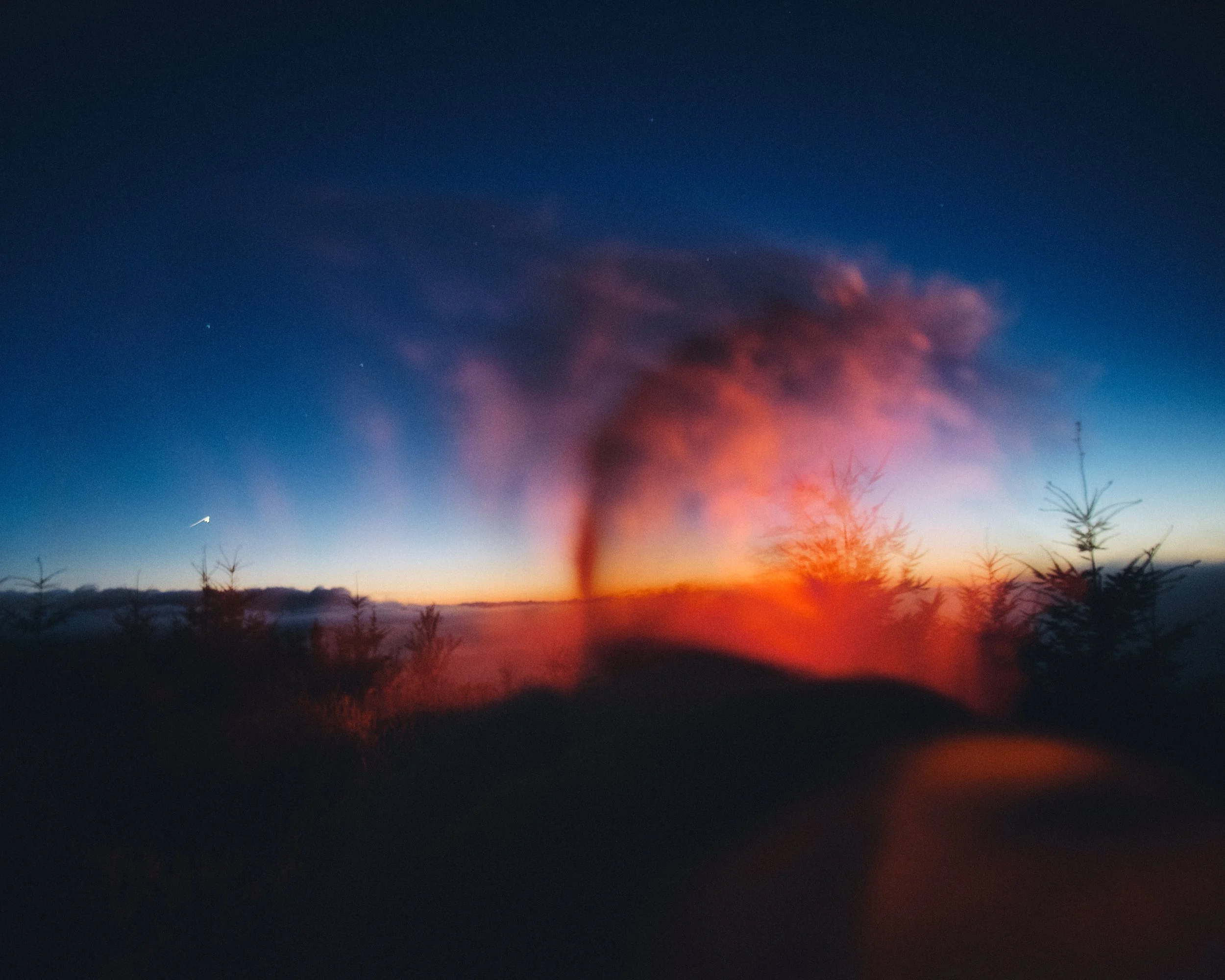 Sunset over the Oregon Coast Range with warm light flare