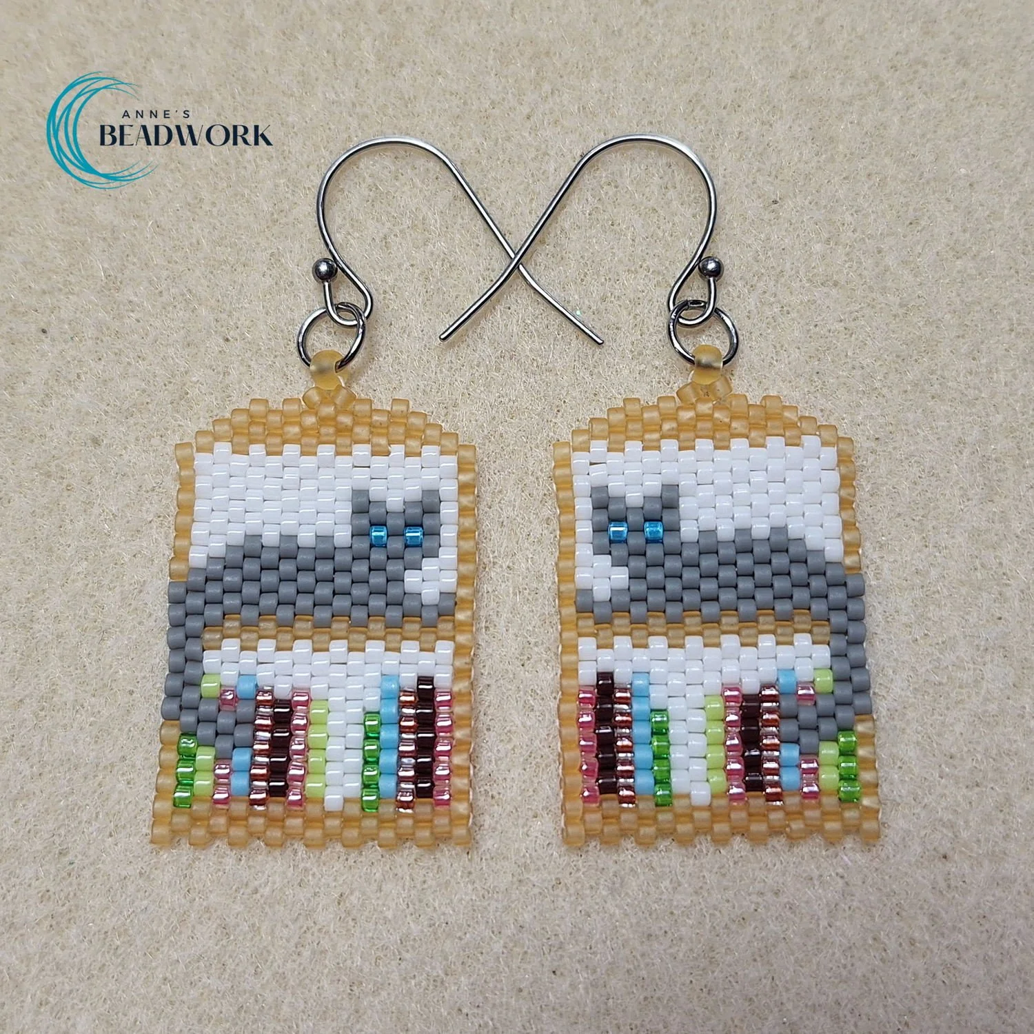 Earring_Peyote_Stitch_Cat_Shelf_HeartOfTheHills_Gray_Cat_Blue_Eyes_Gold_Shelf_20260506.jpg