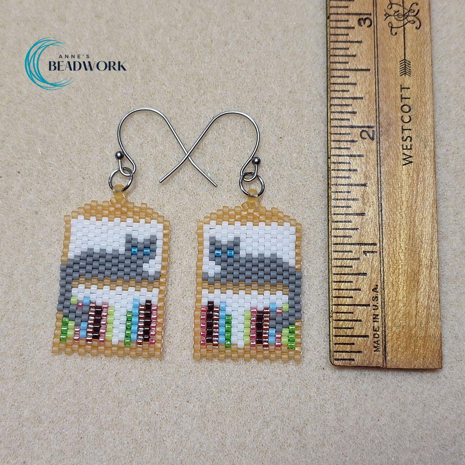 Earring_Peyote_Stitch_Cat_Shelf_HeartOfTheHills_Gray_Cat_Blue_Eyes_Gold_Shelf_20260506_Length.jpg