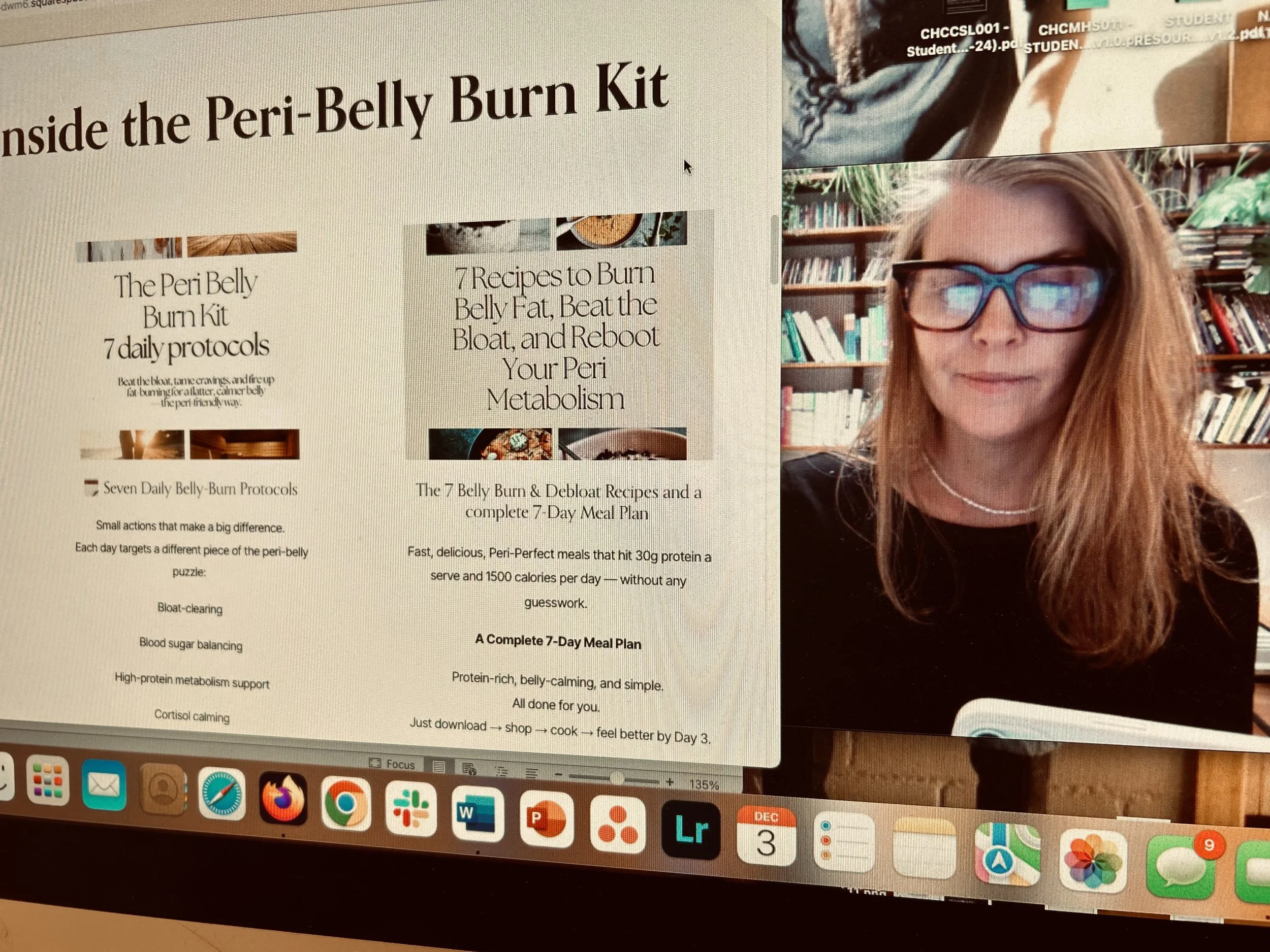 A computer screen displaying a webpage about the 'Inside the Peri-Belly Burn Kit,' with text describing the kit's protocols and meal plan. On the right side, a woman with long red hair, glasses, and a black top is visible in a video call, sitting in a room with bookshelves.
