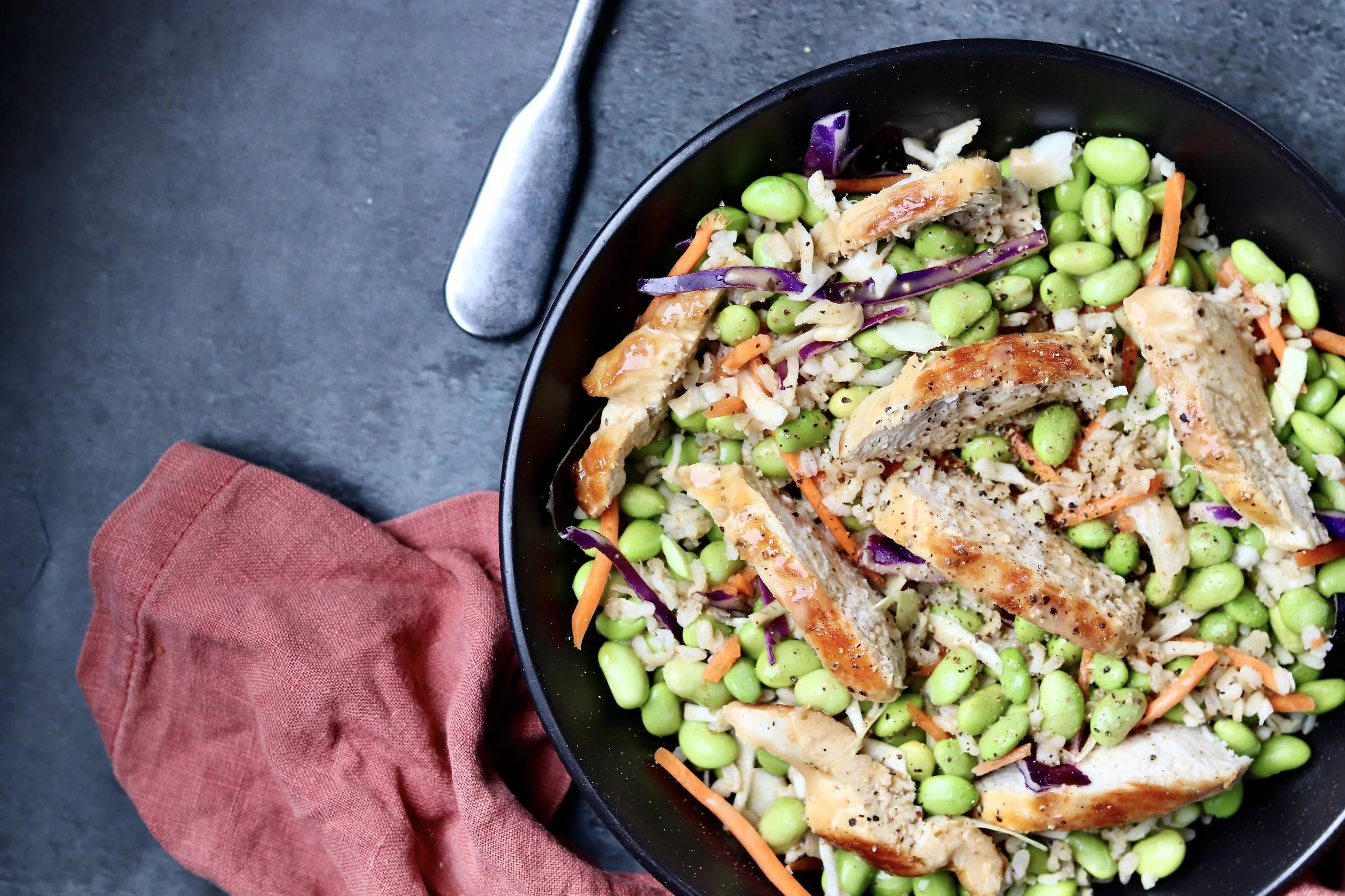 “Chicken miso and edamame power bowl with tender chicken, shelled edamame, fresh vegetables, and a savory miso dressing in a protein-rich, nutrient-dense meal.”