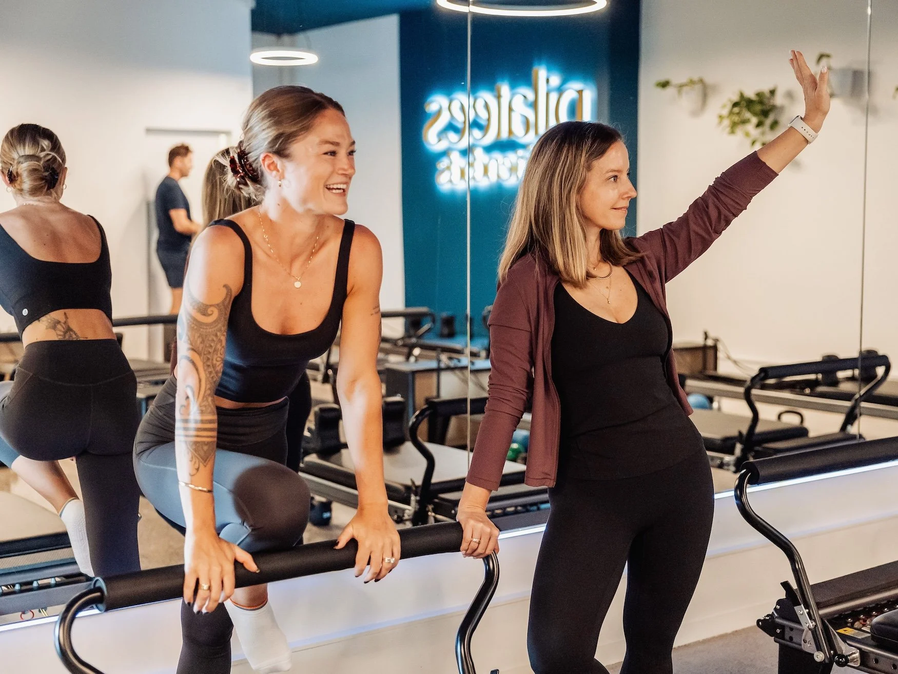 A trainer and class attendee at a reformer pilates class at Pilates & Friends in Auckland.