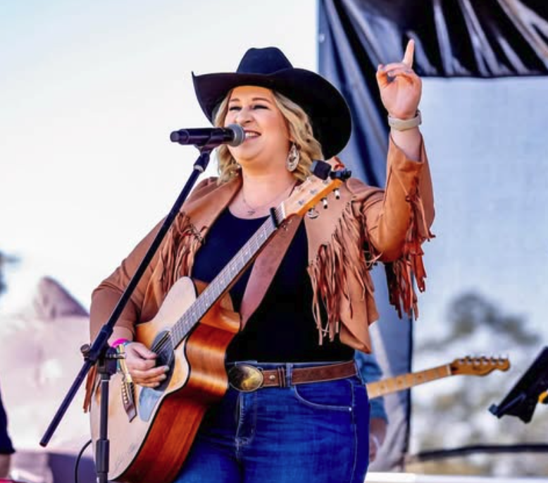 image of chloe swannel playing guitar and singing