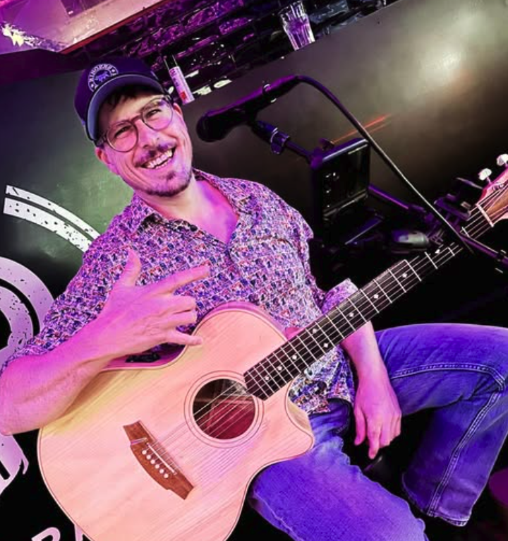picture of johnny wood smiling with guitar 