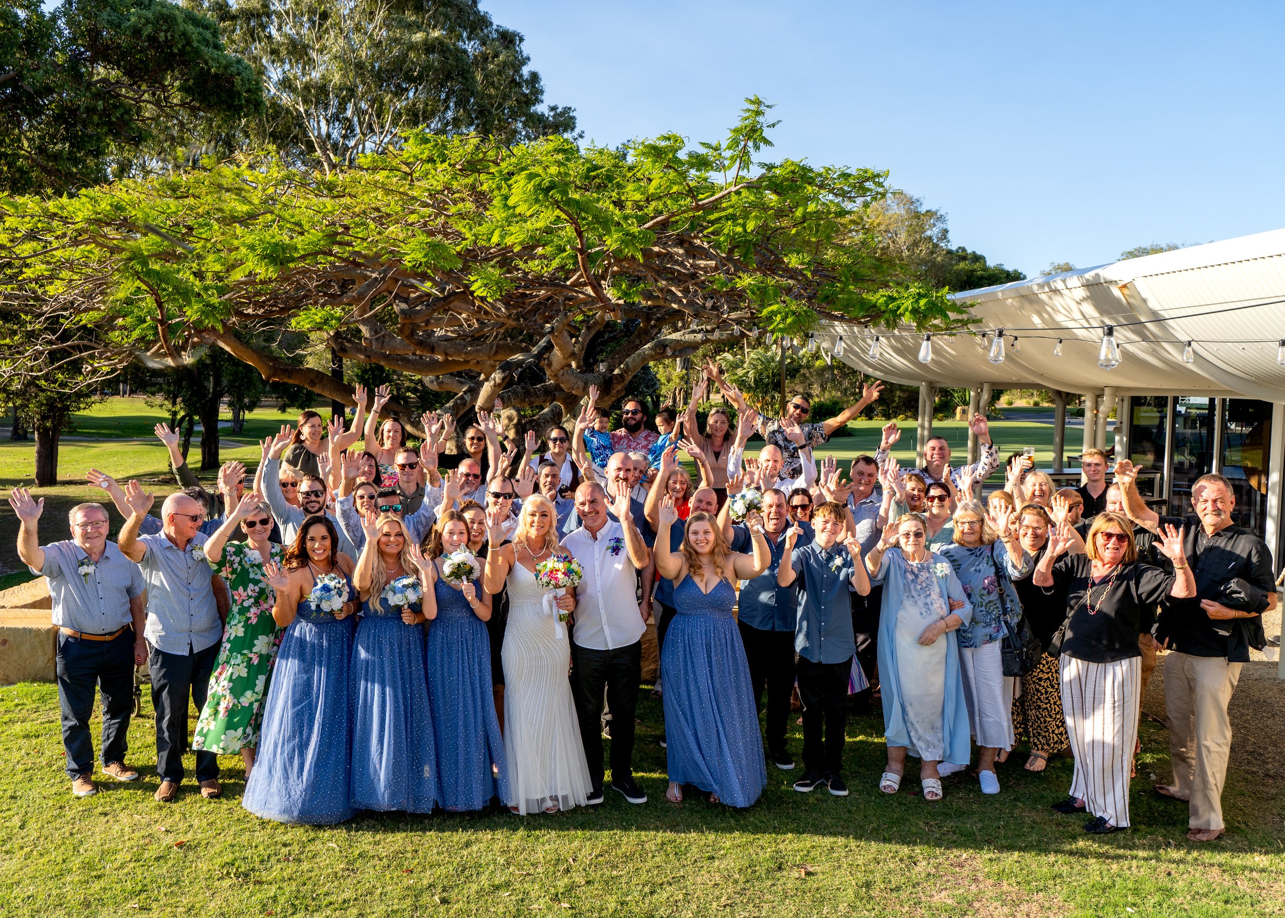 A family of three, a man, woman, and a newborn baby, smiling and looking at each other in a warmly lit room.