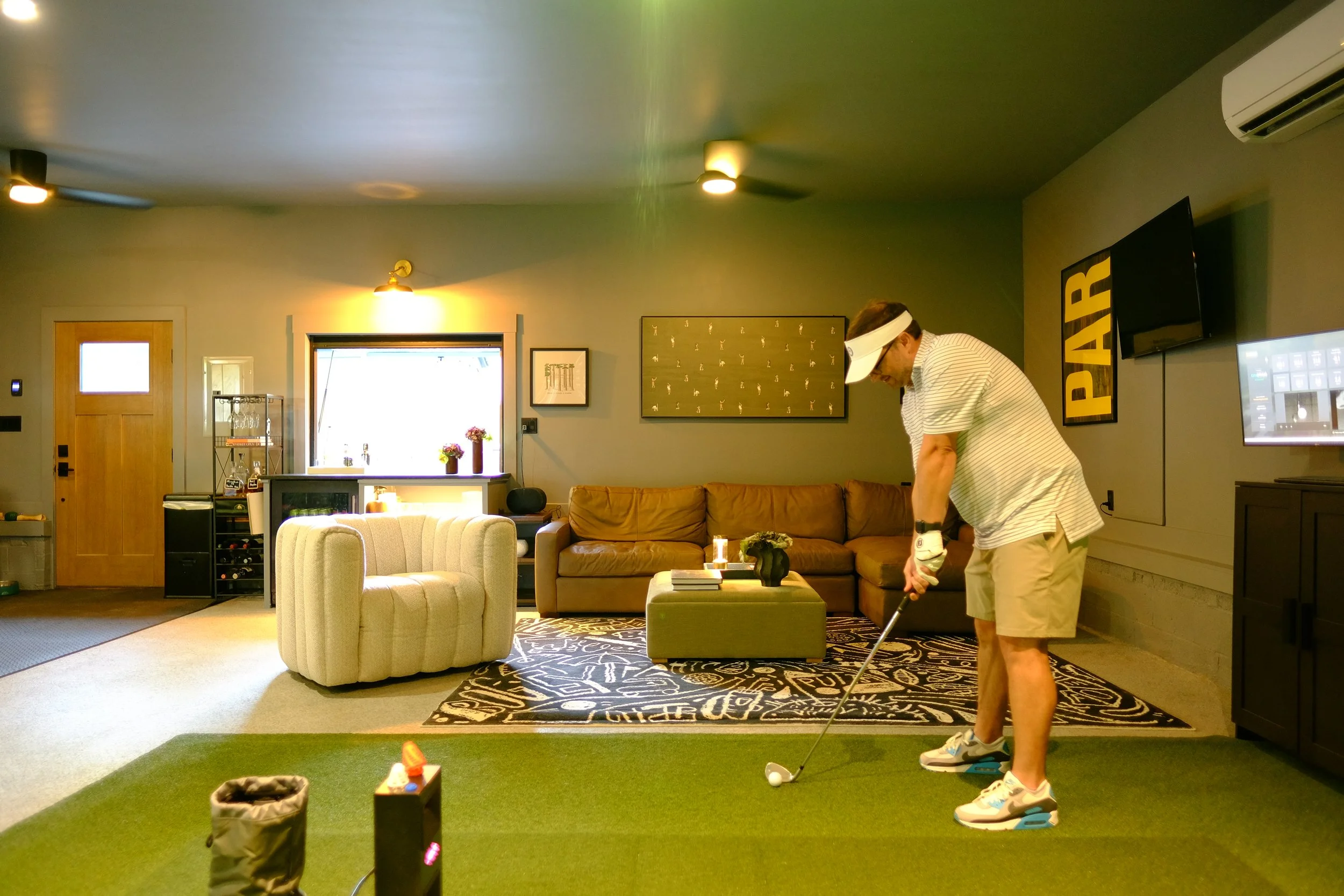 leather sectional, swivel armchair, storage ottoman, golf simulator 