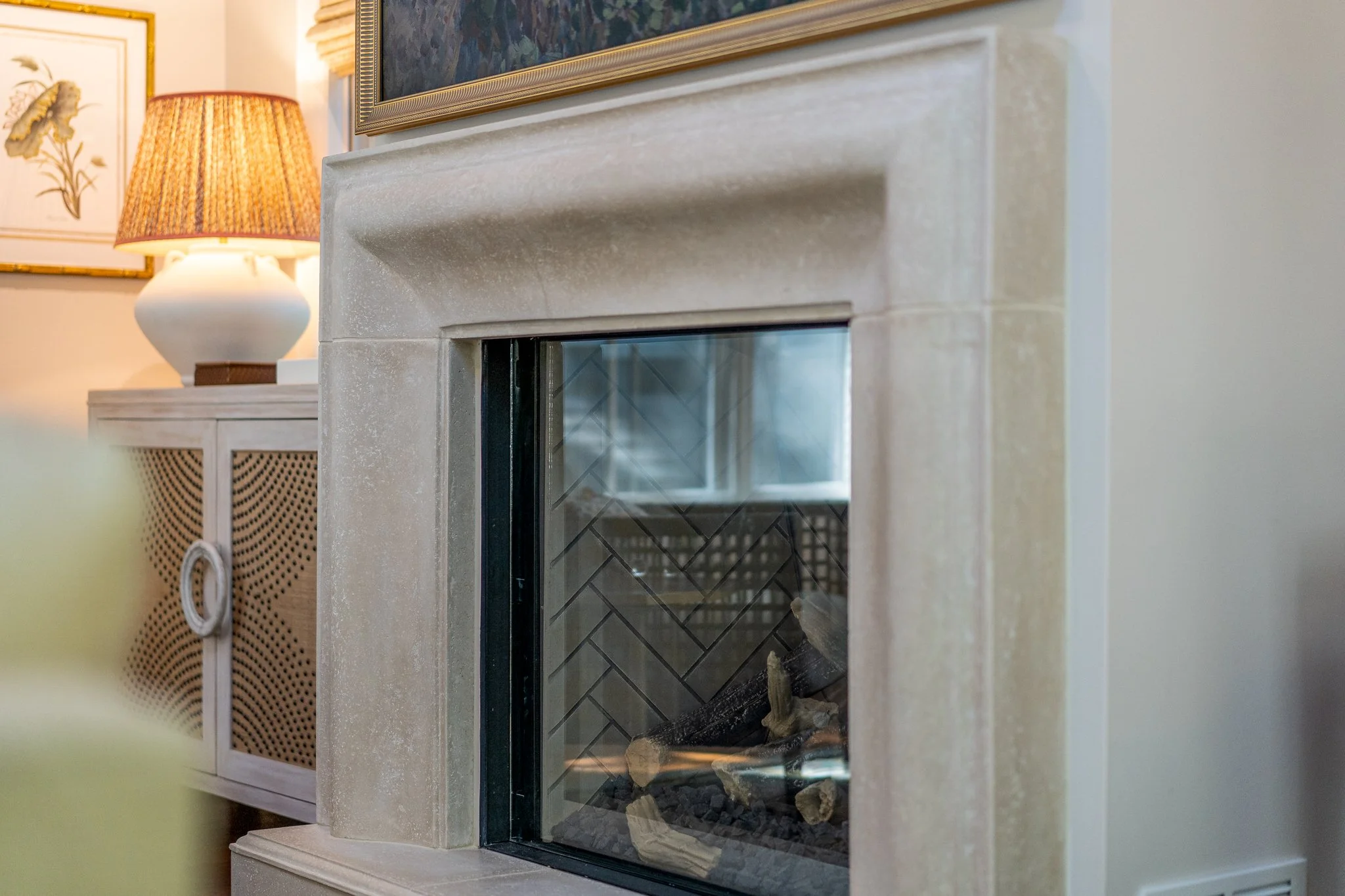 Sculptural rustic cast stone gas fireplace in a living room designed by Mimi Interiors