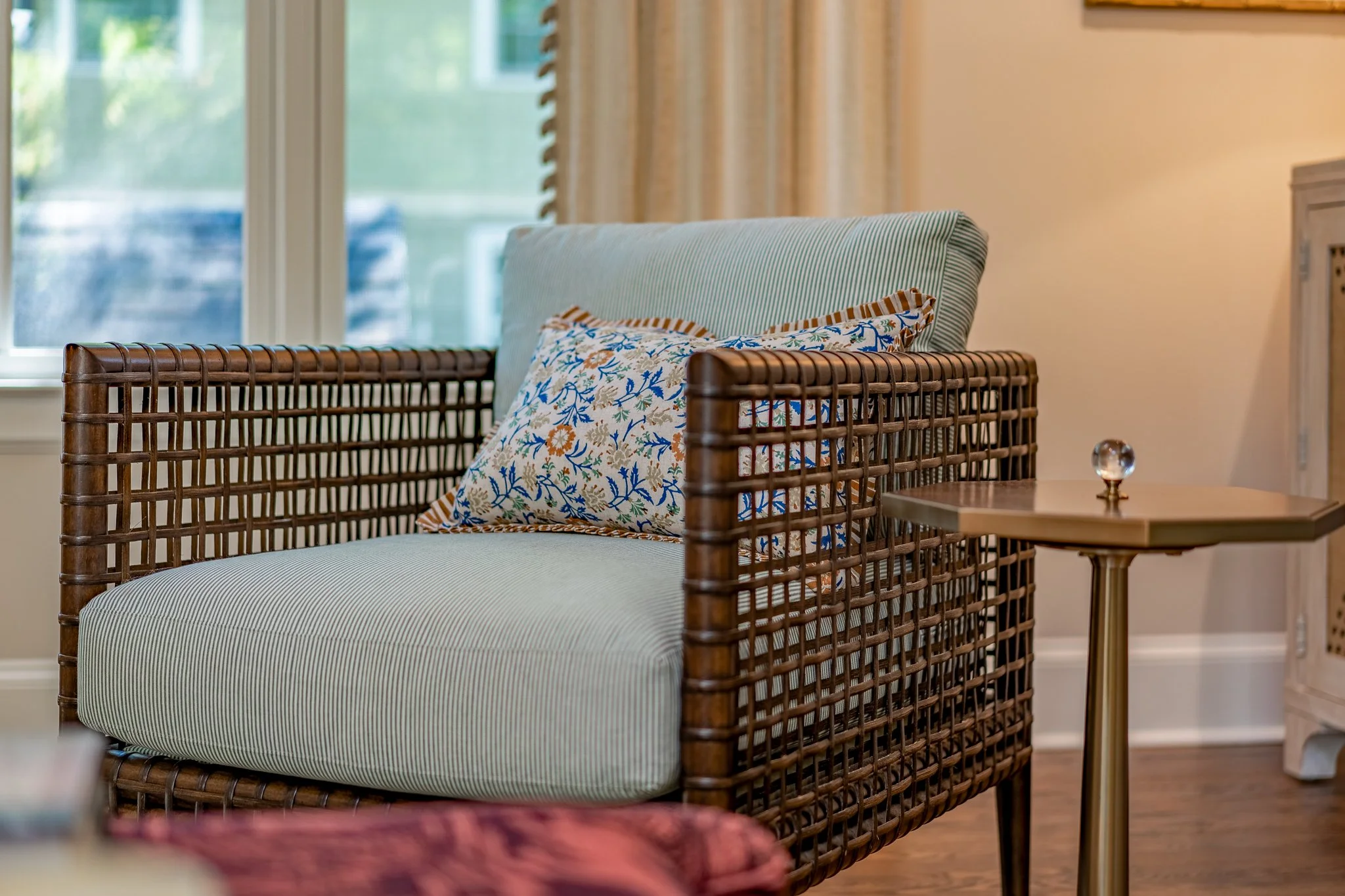 Cane armchair with green and white striped cushion in an indoor-outdoor living space