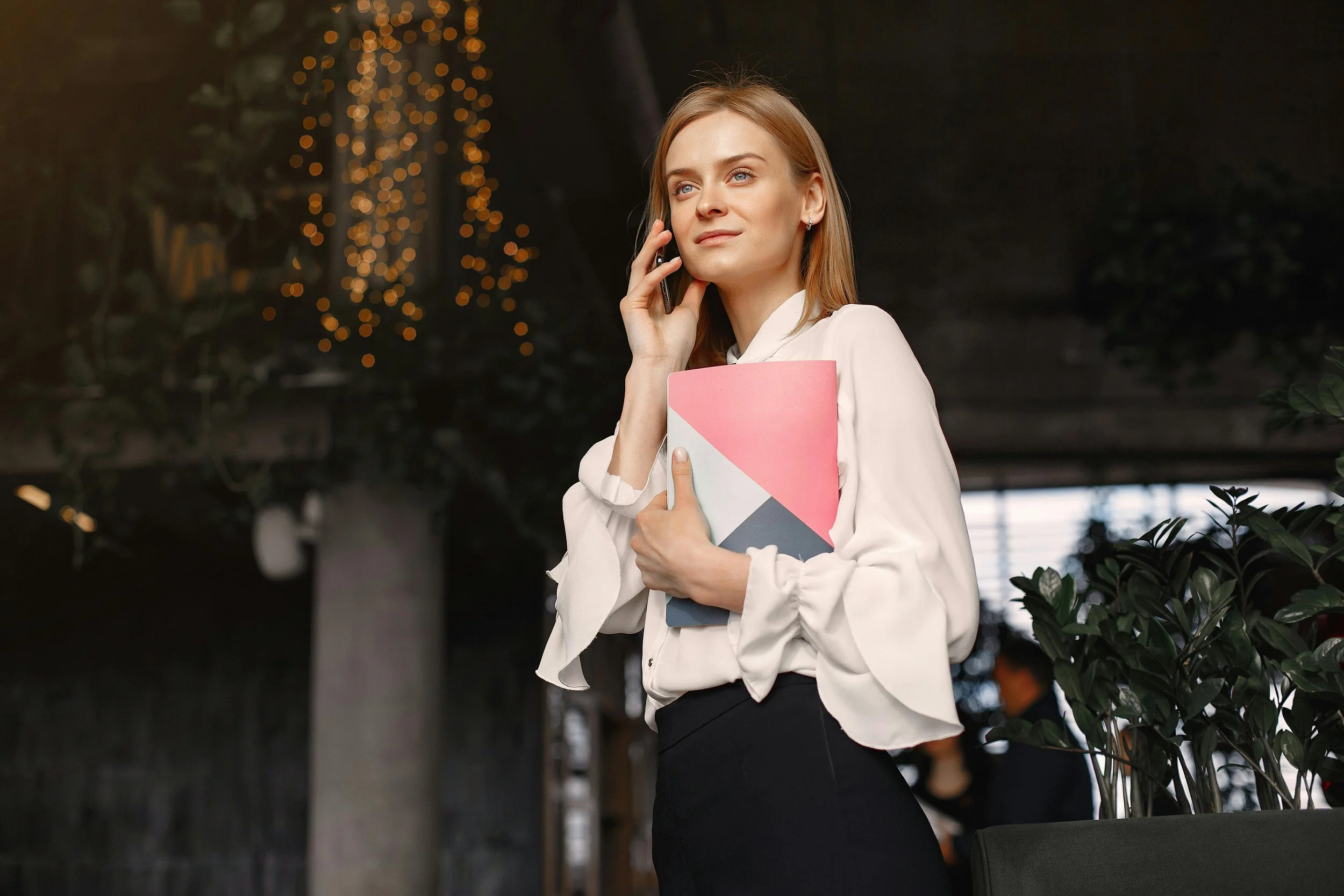 Confident business professional on phone holding documents outdoors